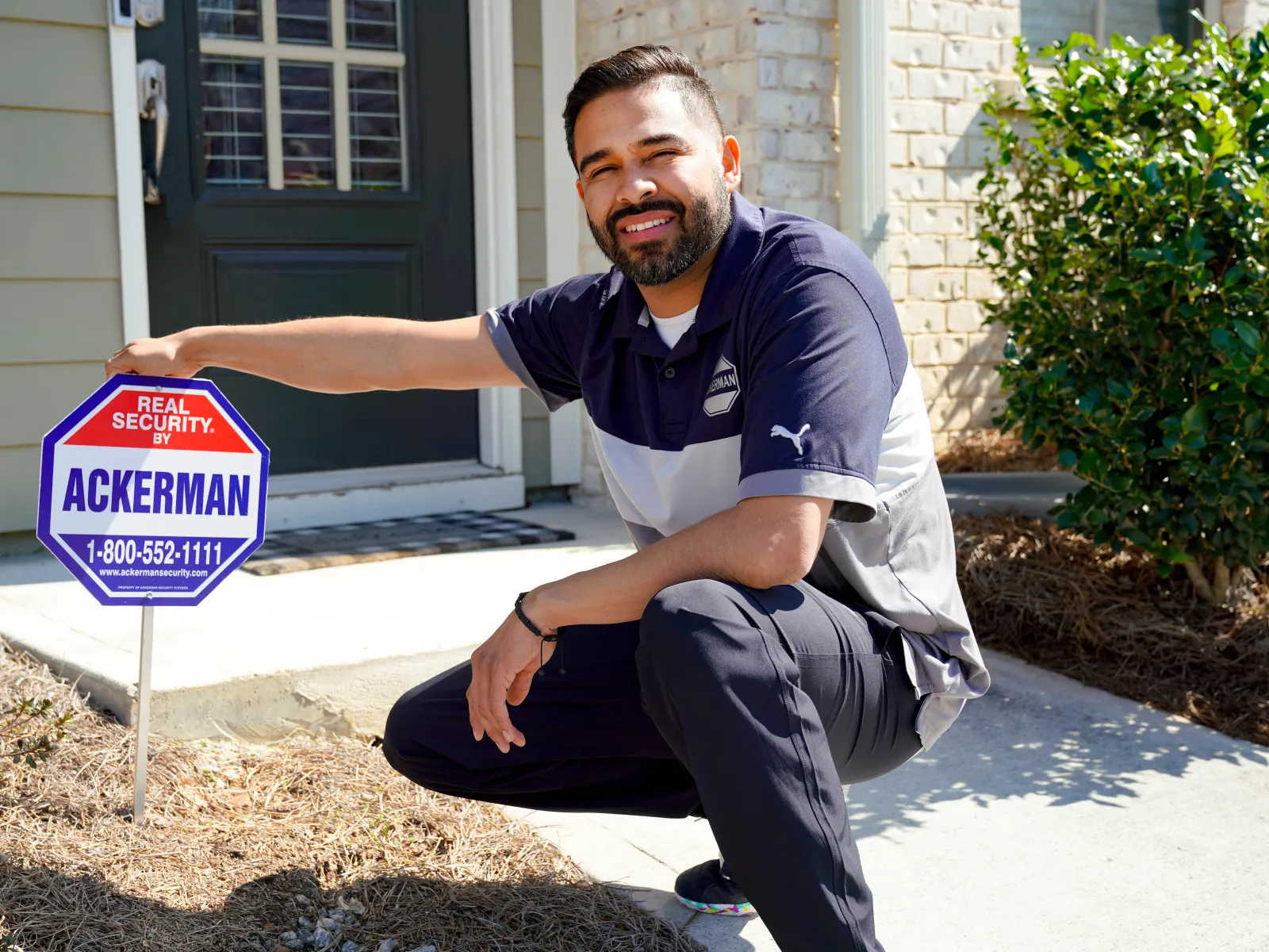 a man sitting on a curb next to a sign