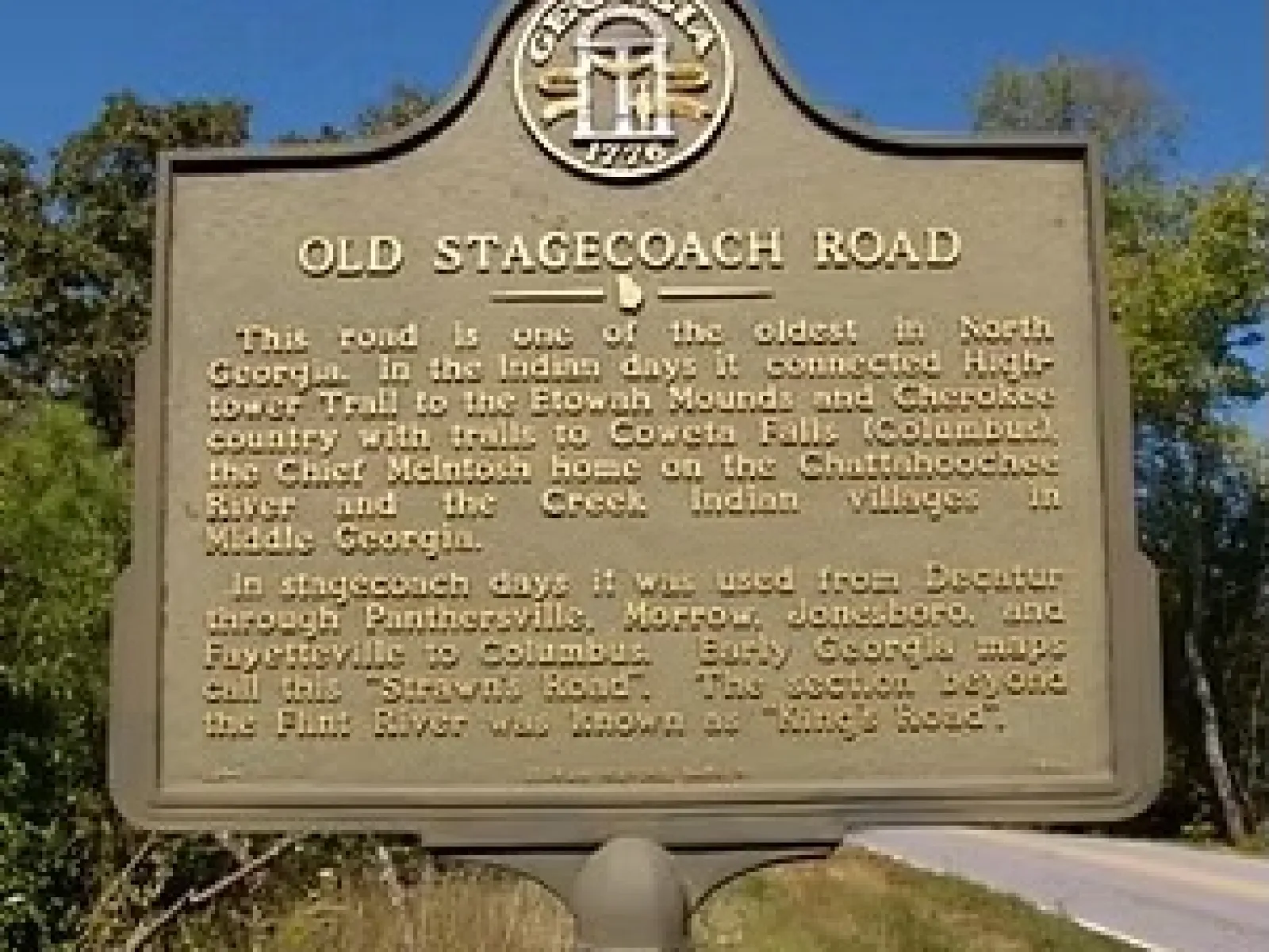 Historic Old Stagecoach Road marker detailing its significance in North Georgia's history near a rural roadside.