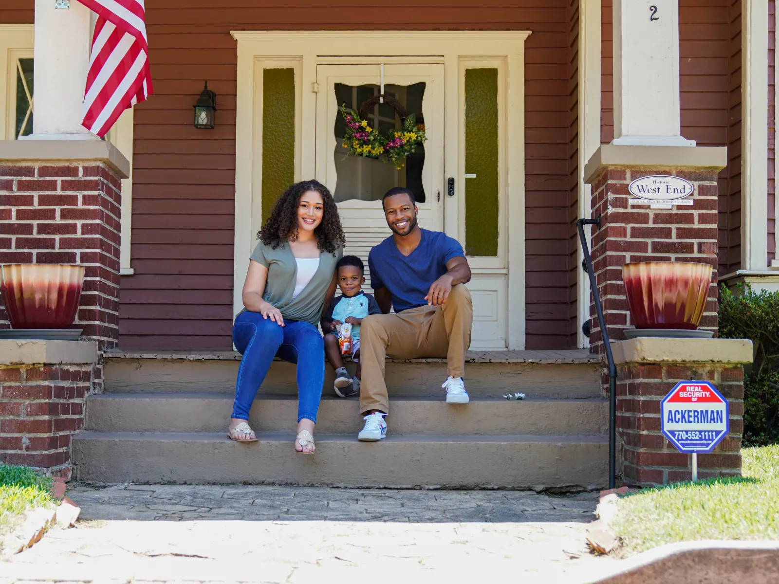 a family sitting on steps outside a house