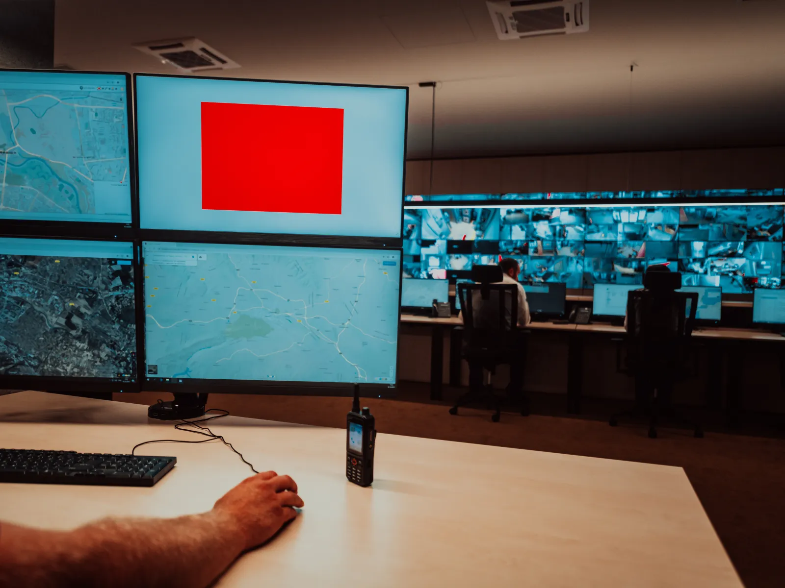 a person sitting at a desk in front of a large screen