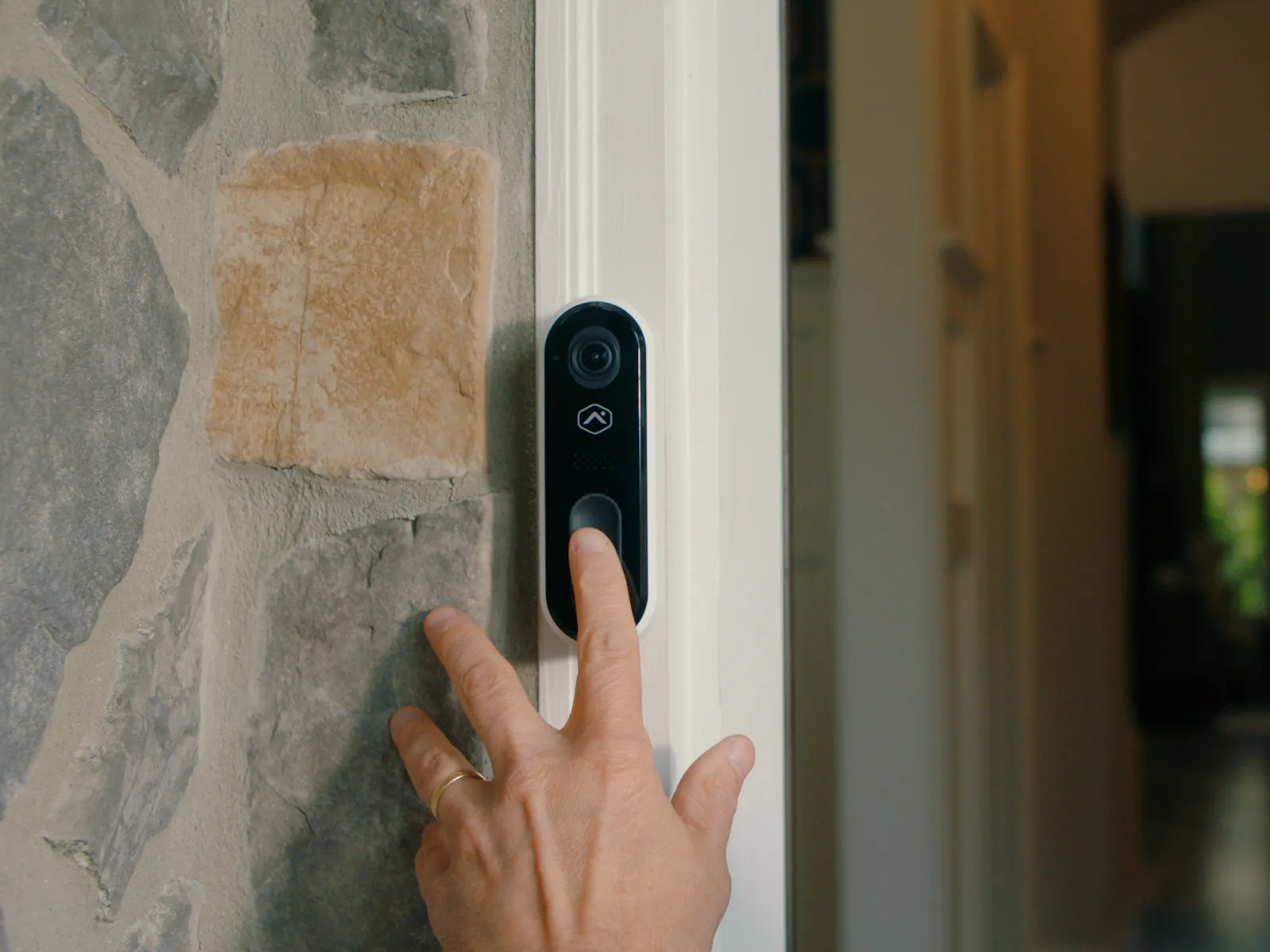 a hand touching a doorbell