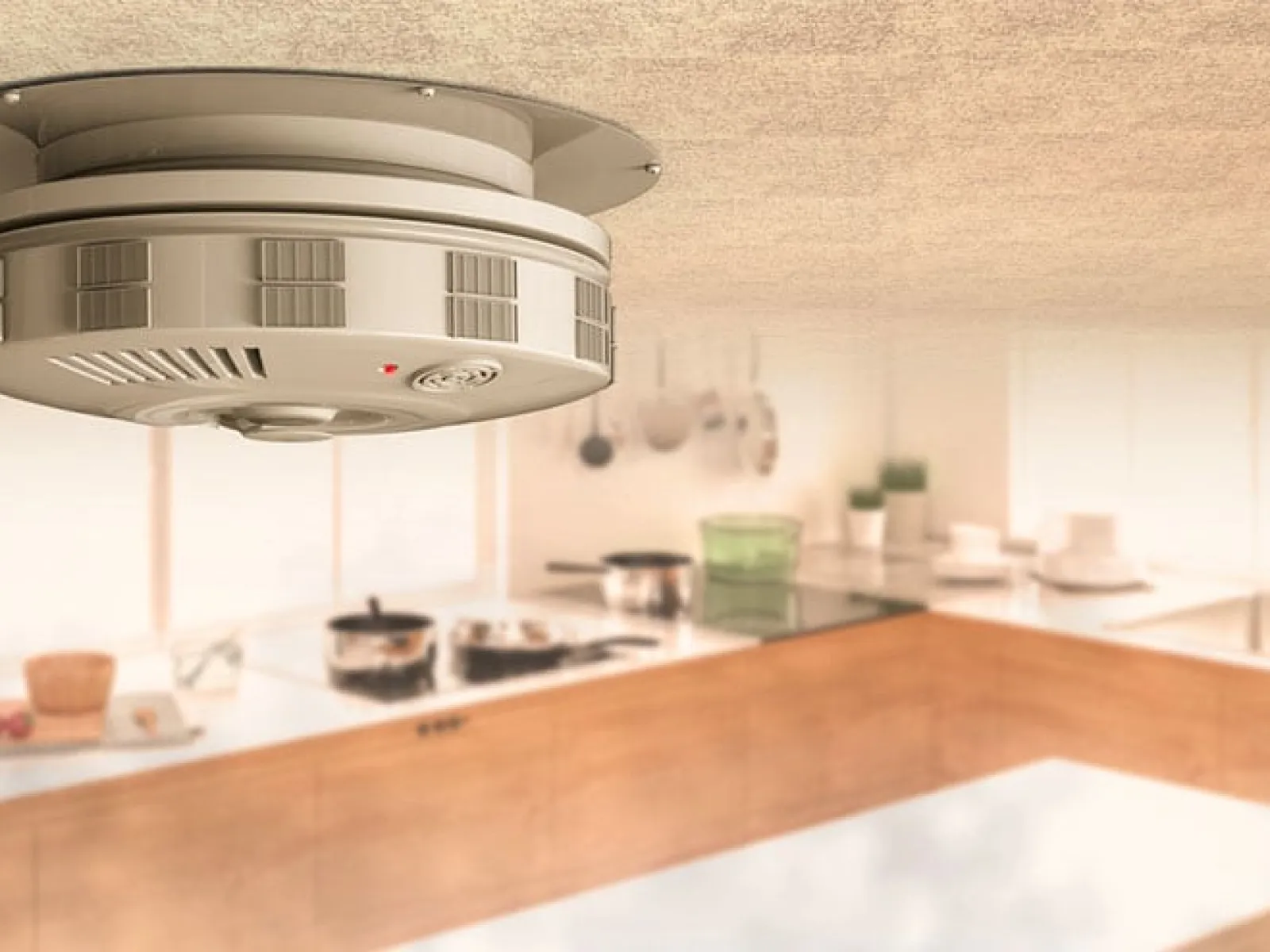 Smoke detector installed on ceiling in bright modern kitchen with wooden cabinets and utensils.