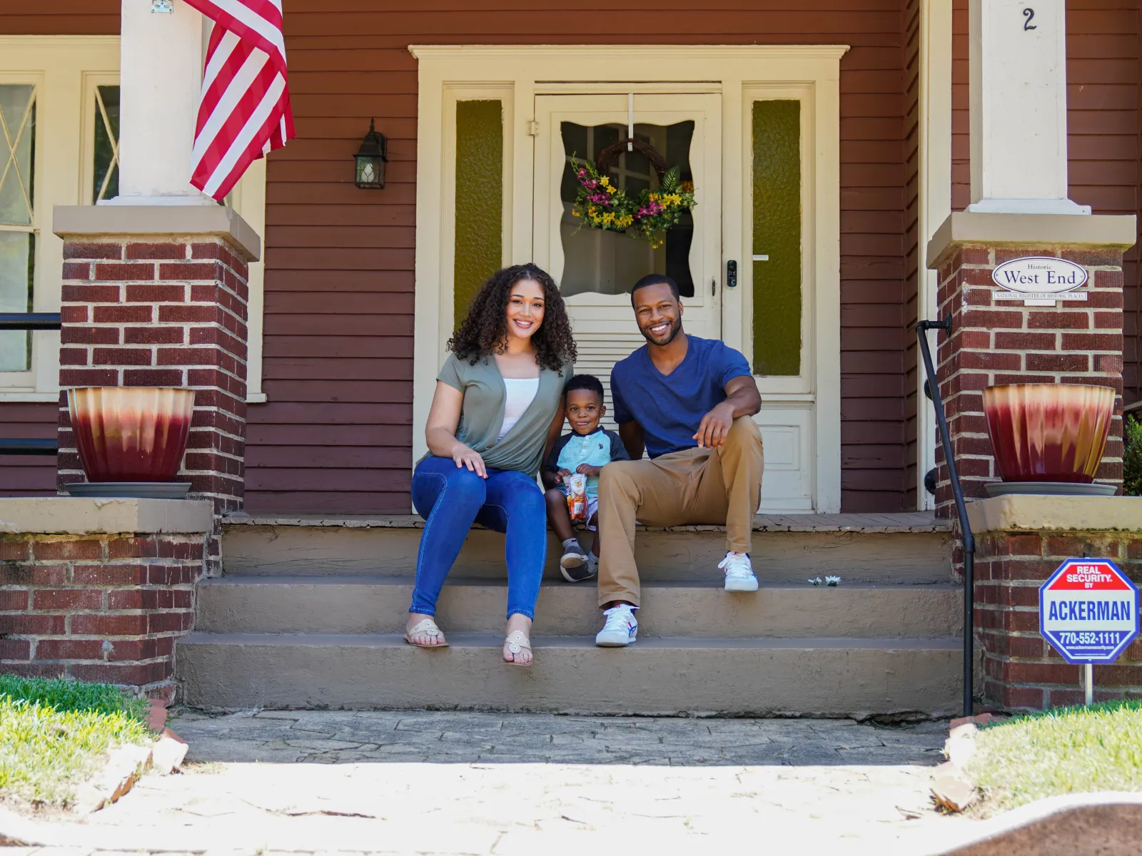 a family sitting on steps outside a house