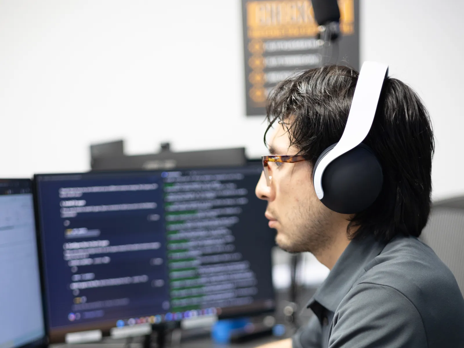 a person wearing headphones and sitting at a desk with a cup of coffee