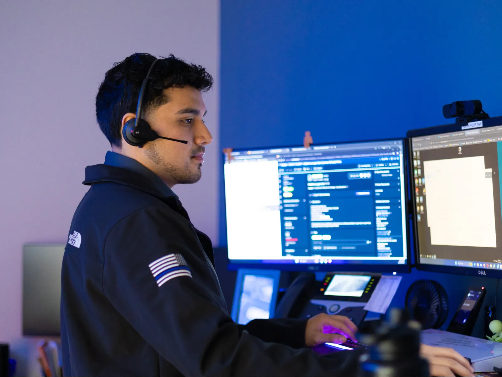 a man wearing headphones and sitting at a desk with a computer