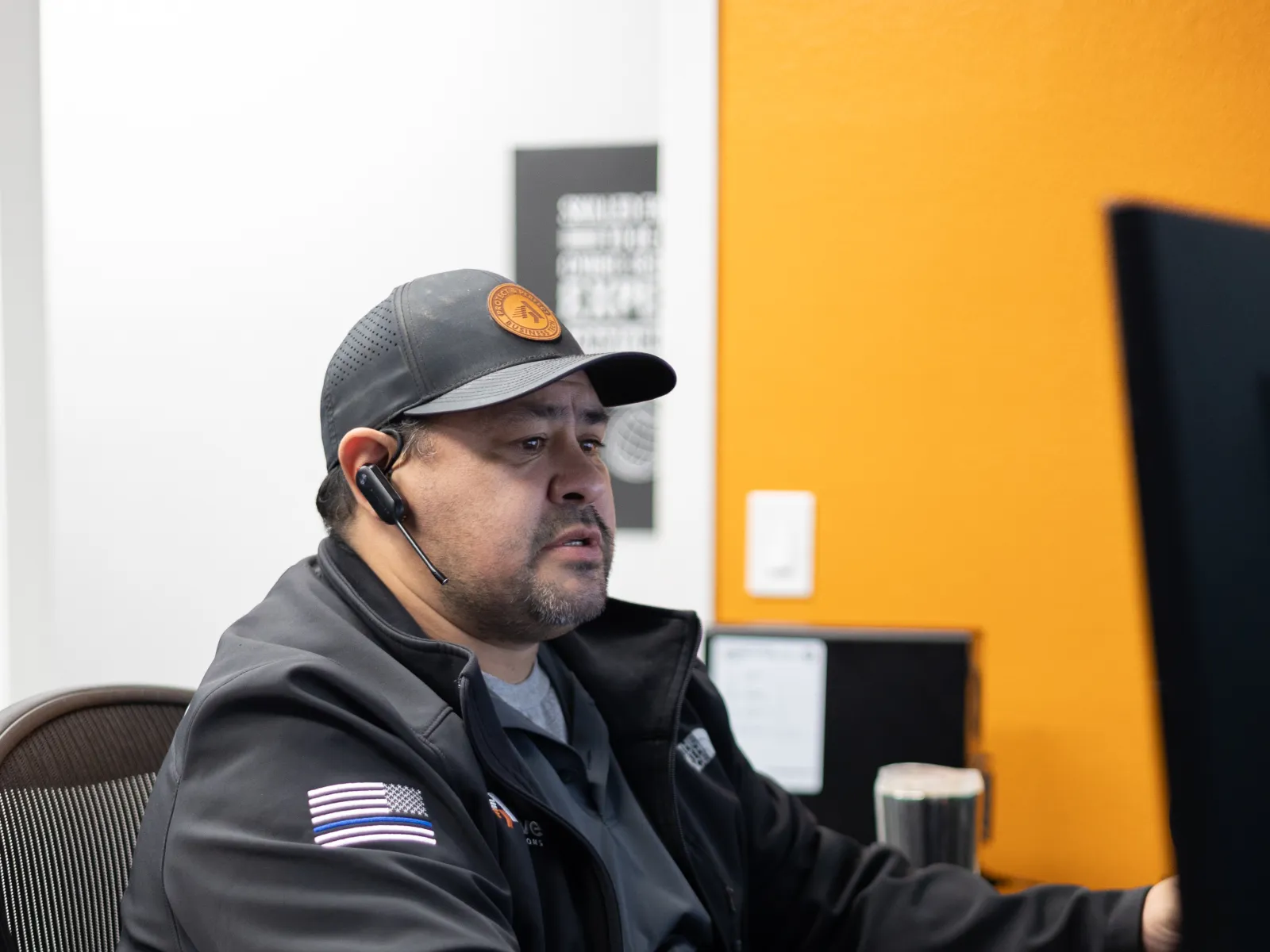 a man sitting at a desk with a computer and headphones on