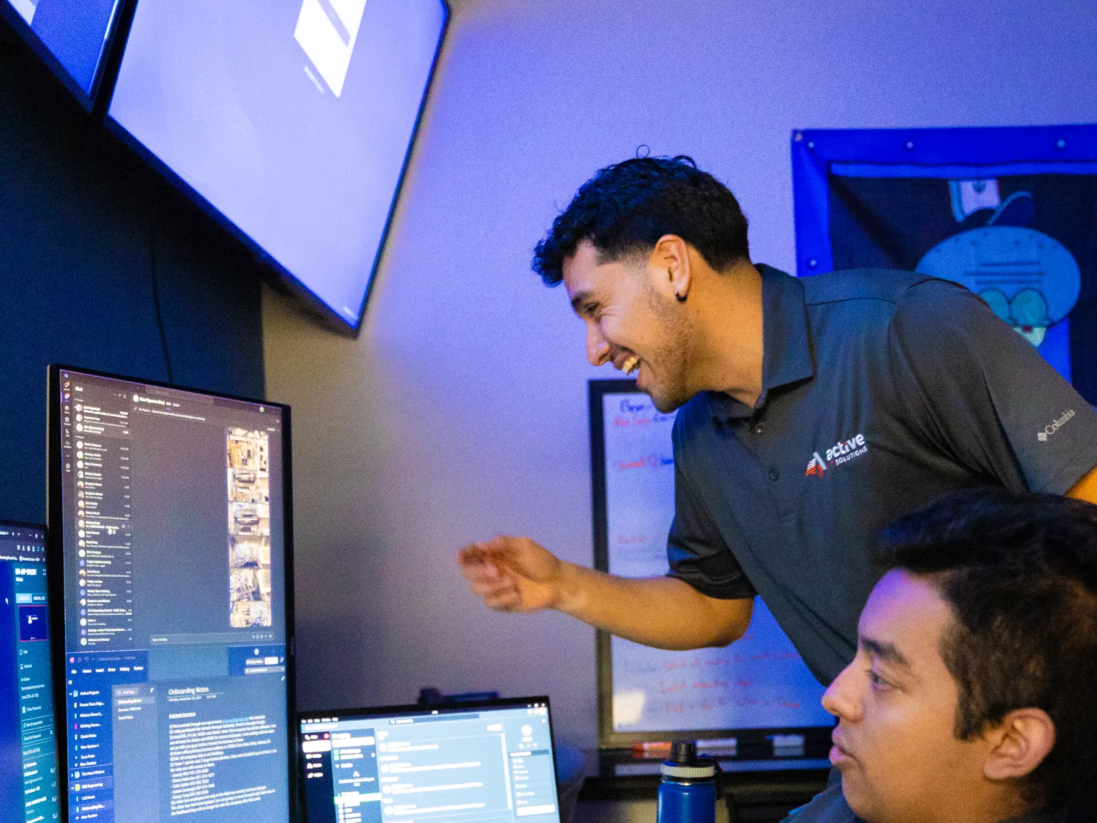 a couple of men looking at a computer screen