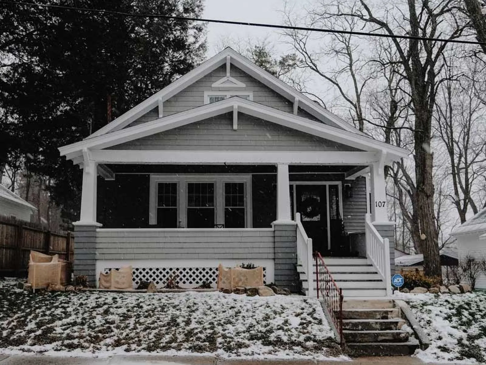 a house with a porch and snow on the ground