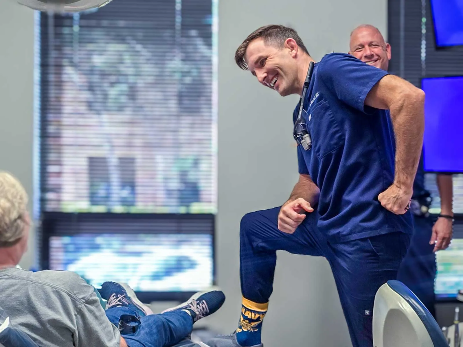 Smiling male dentist engaging with patient during consultation in a bright dental office setting