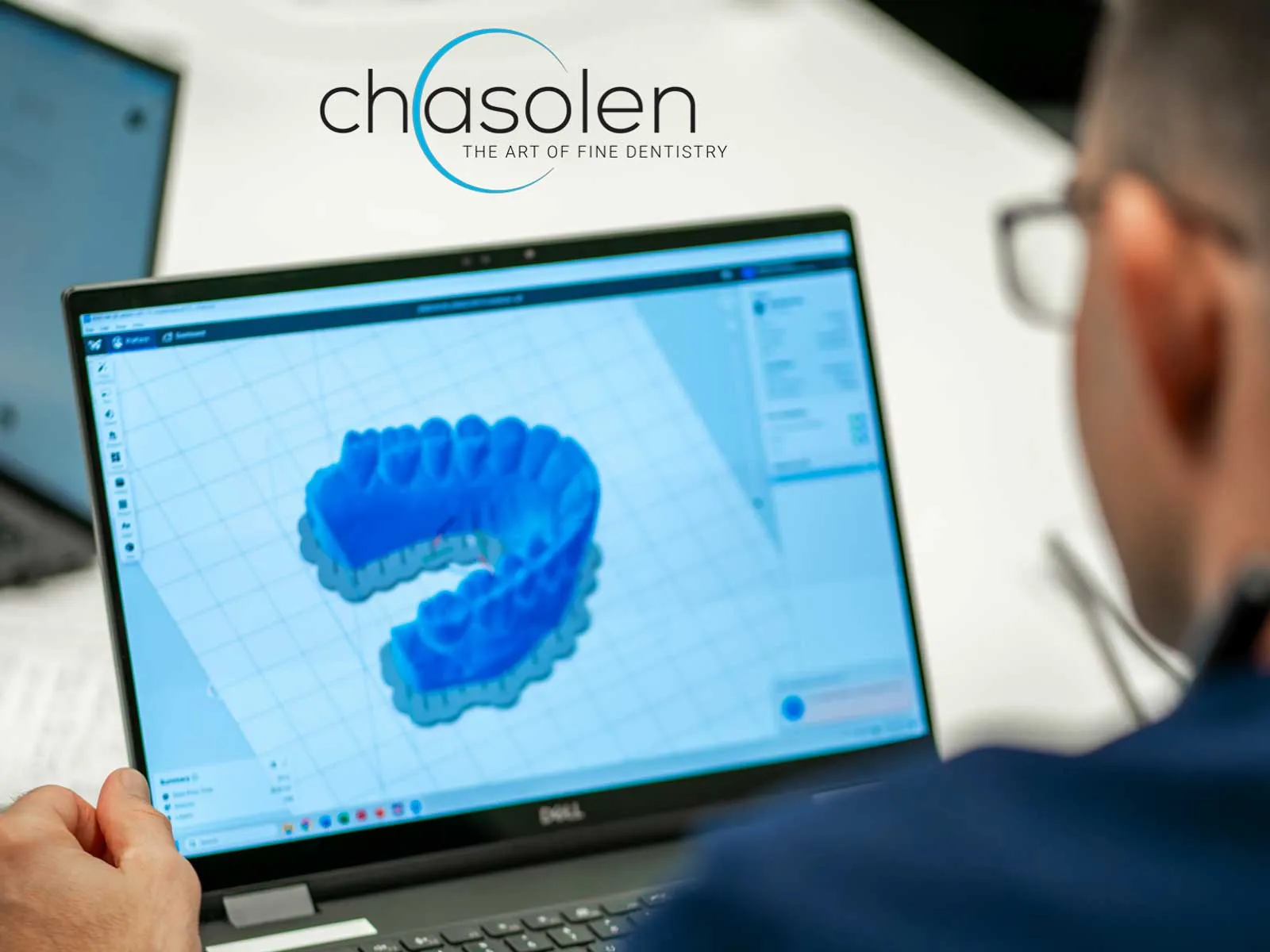 Modern dental exam room with chair, overhead light, dual monitors, and large window with blinds