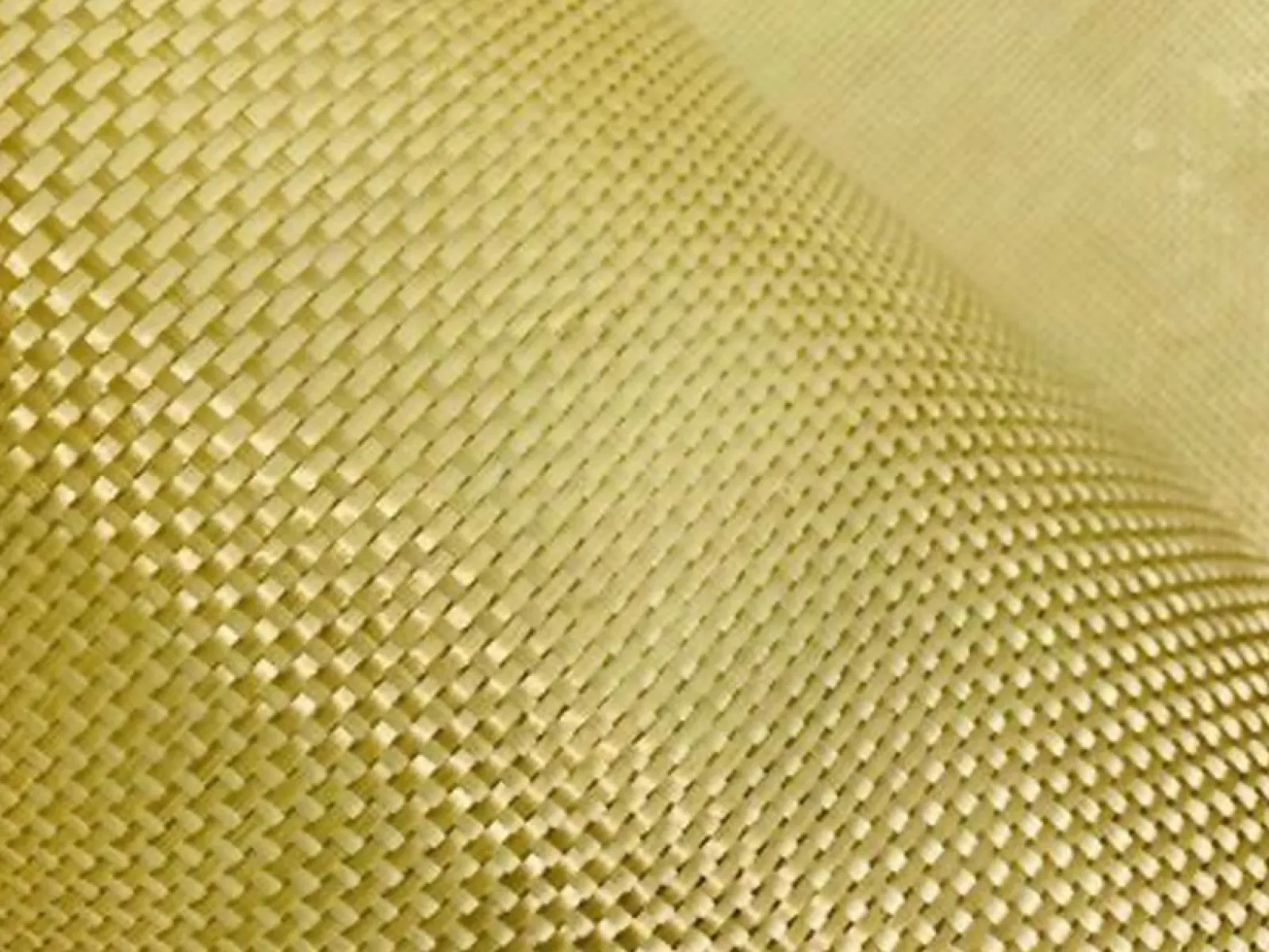 Close-up of woven golden fabric with a detailed textured pattern and curved surface.
