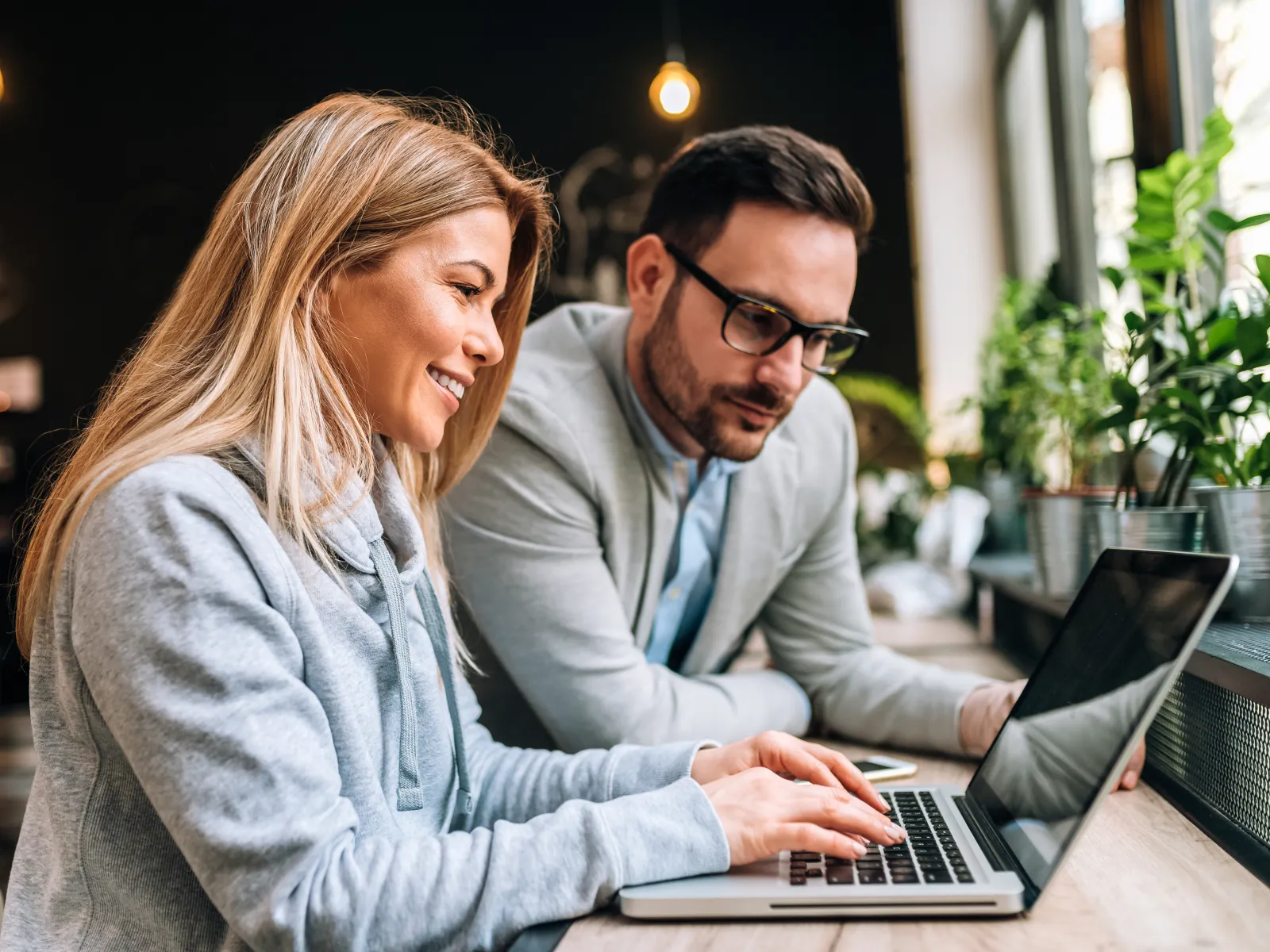 a man and a woman looking at a laptop