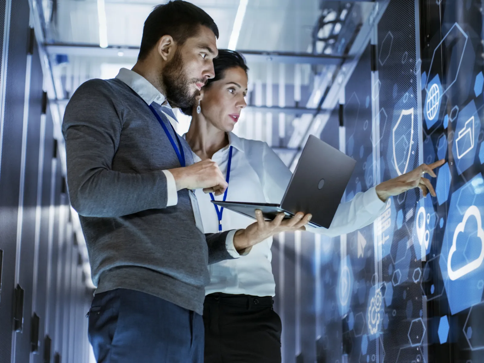 a man showing something on the laptop to a woman