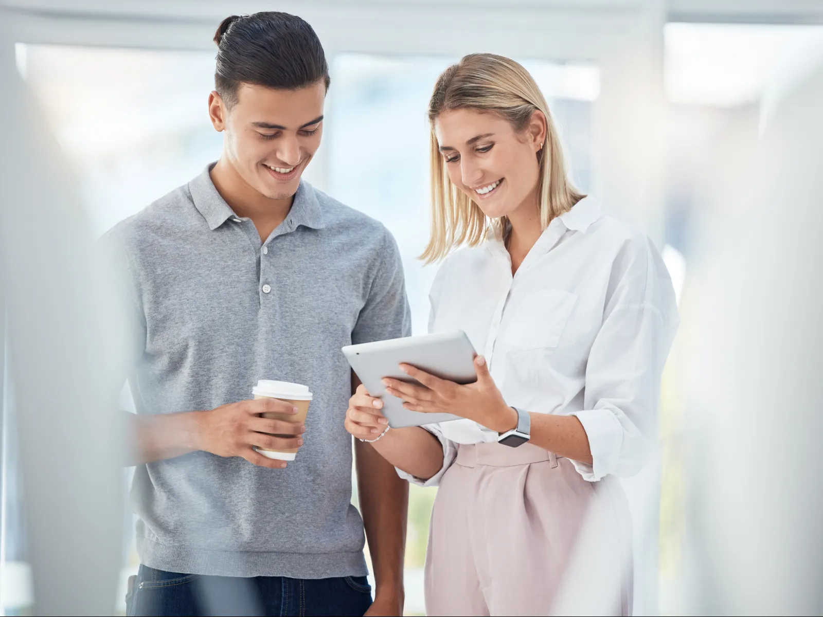 a man and a woman looking at a tablet