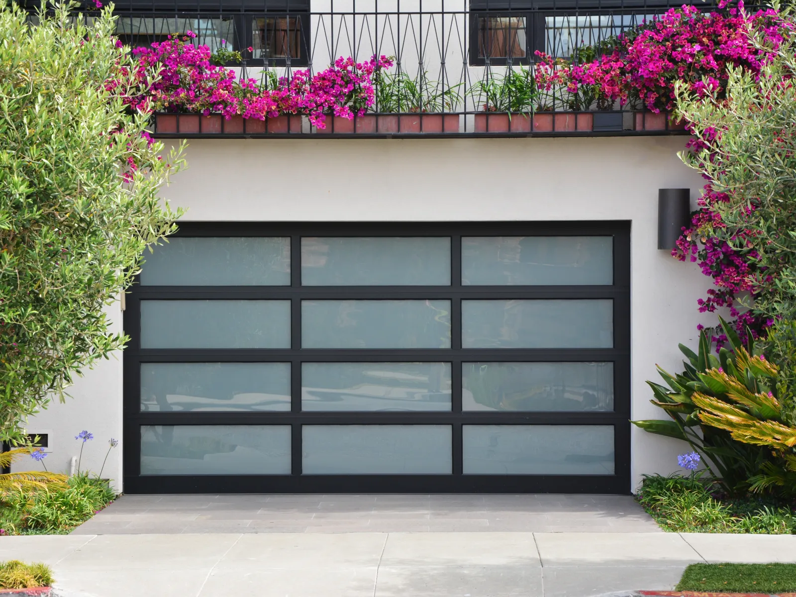 a garage door with flowers on the roof