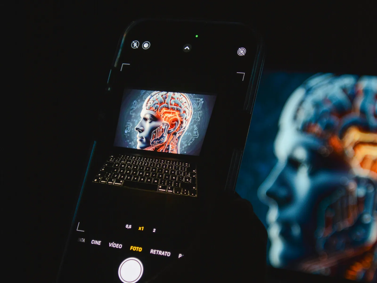 Smartphone capturing an image of a digital brain illustration with glowing neural pathways on a laptop screen.