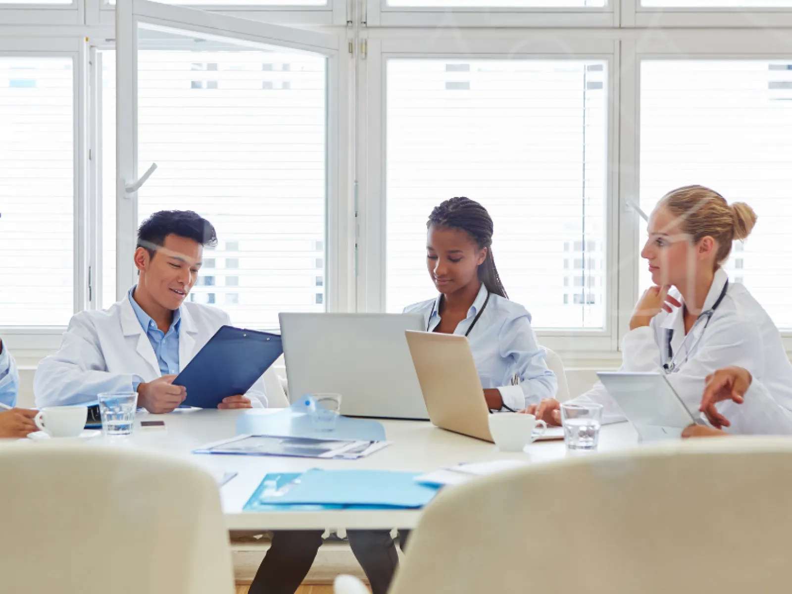 Medical team discussing patient data and research during a meeting in a bright conference room