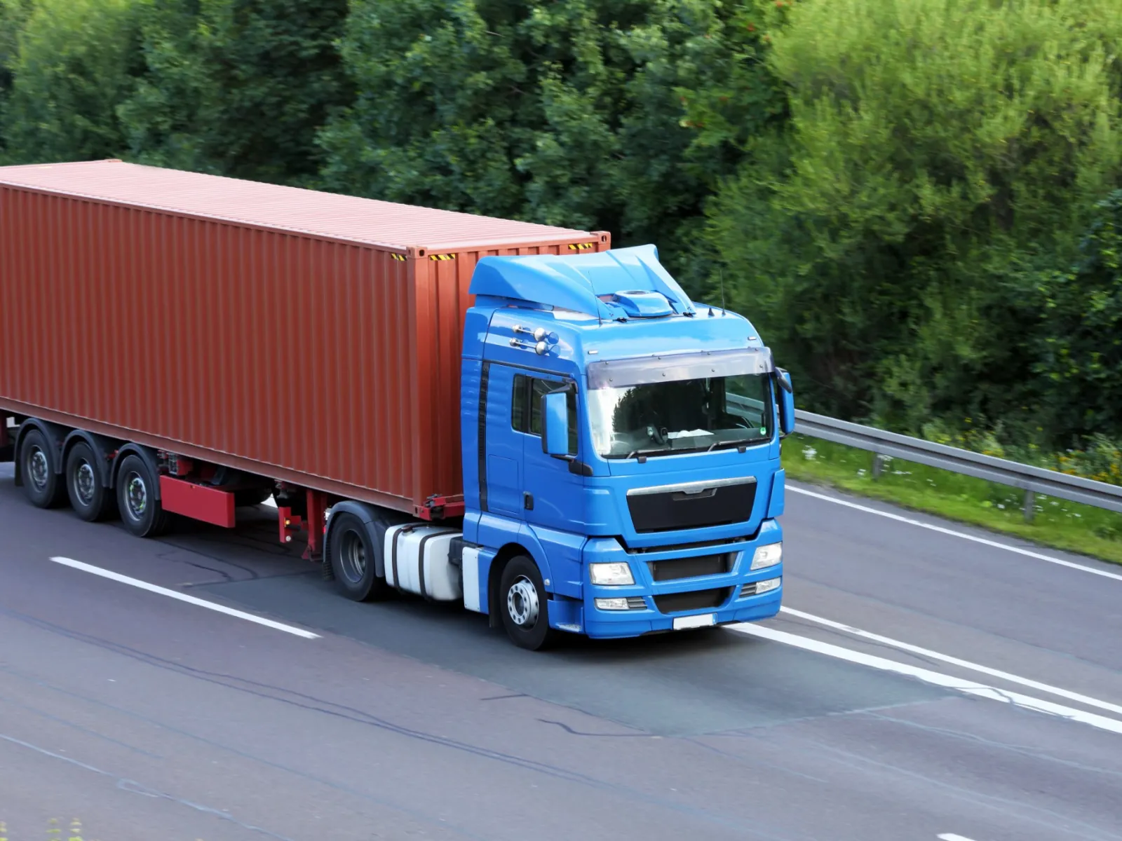 a blue truck carrying a container