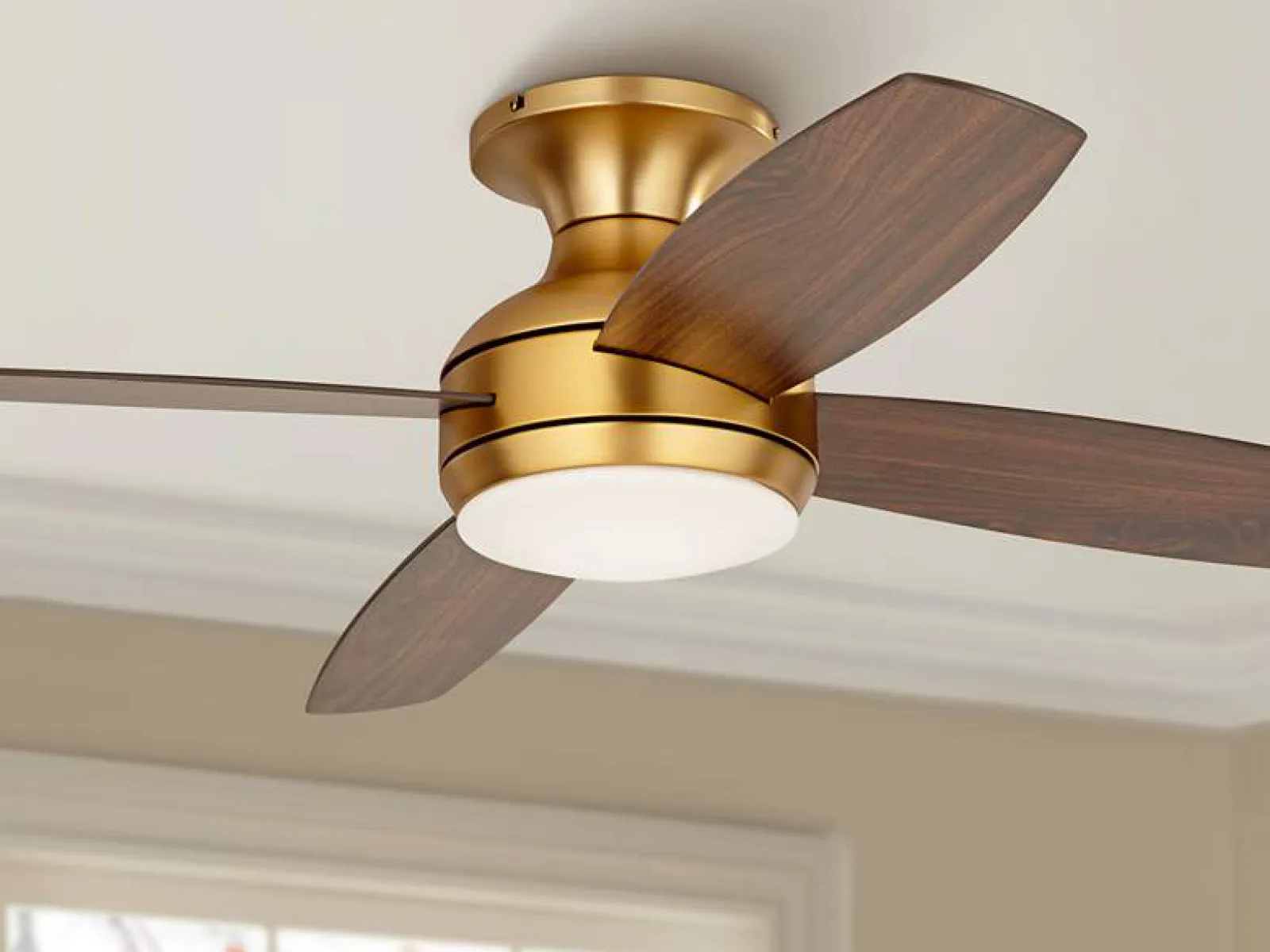 A new ceiling fan with a gold finish and wooden blades installed