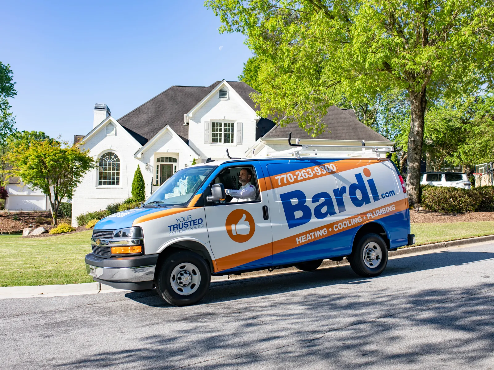 Bardi heating, cooling, and plumbing service van parked in front of a suburban house on a sunny day.