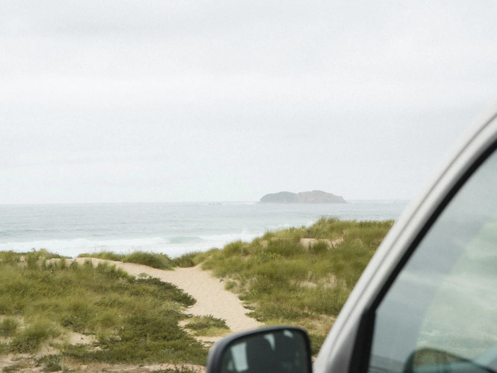 a car driving on a road next to a body of water