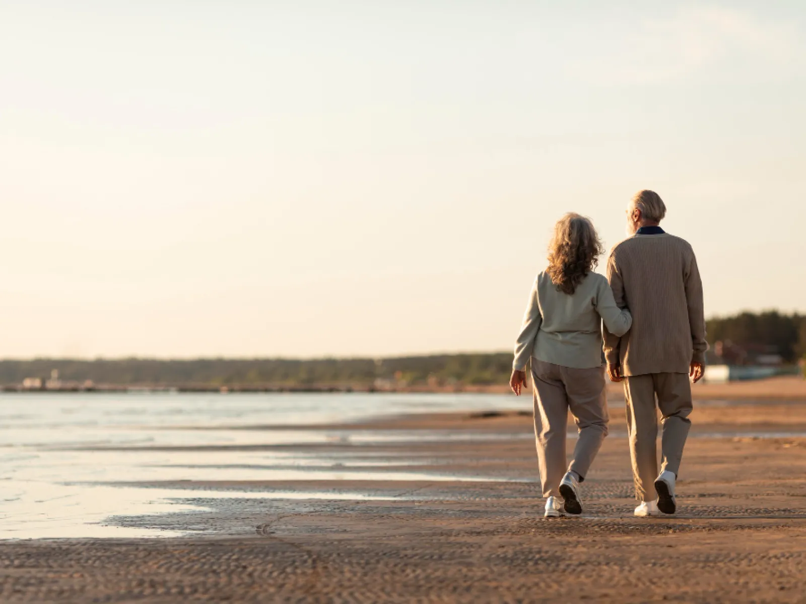 a man and woman walking on a beach