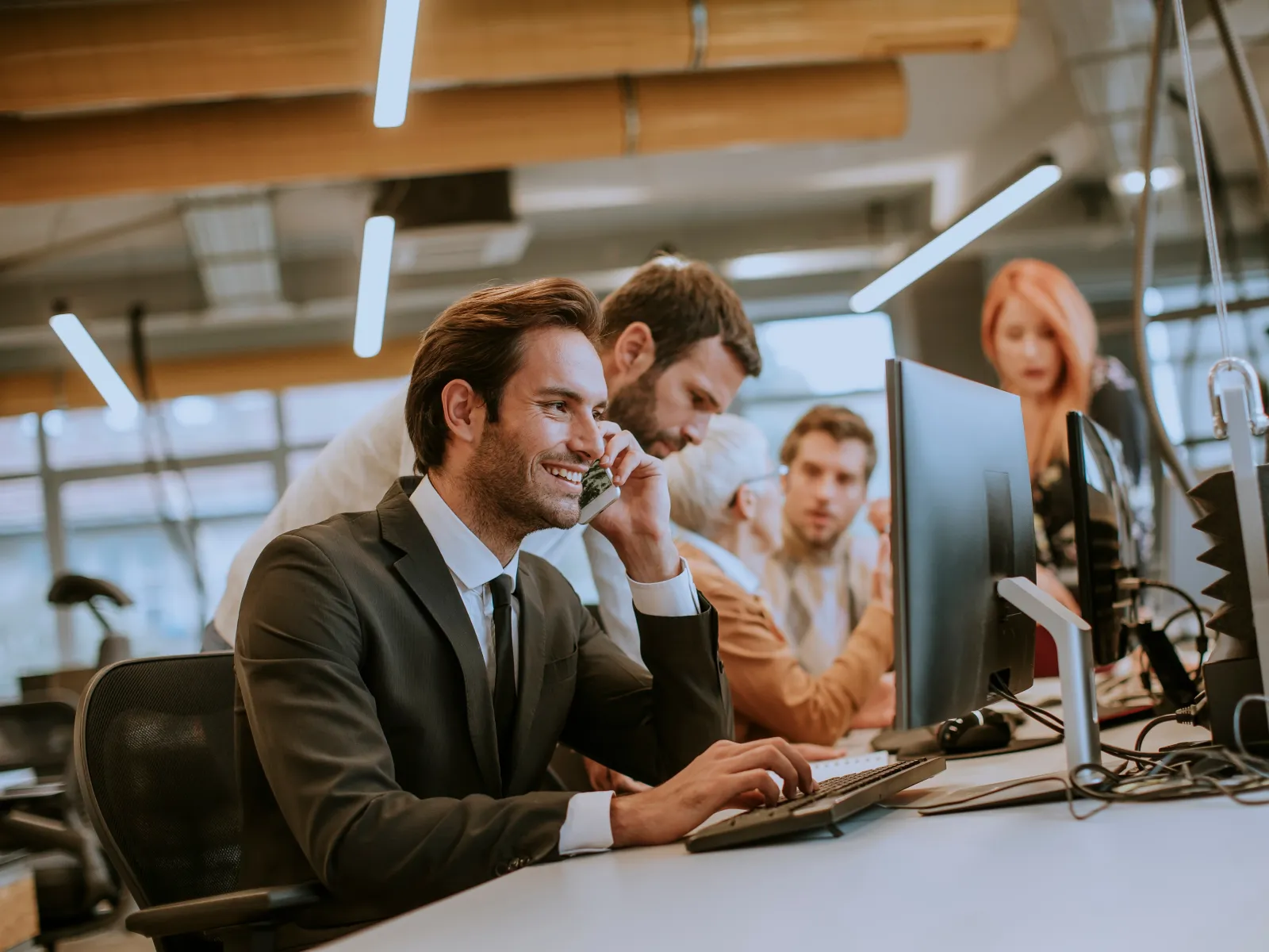 Business professionals collaborating in a modern office environment with computers.