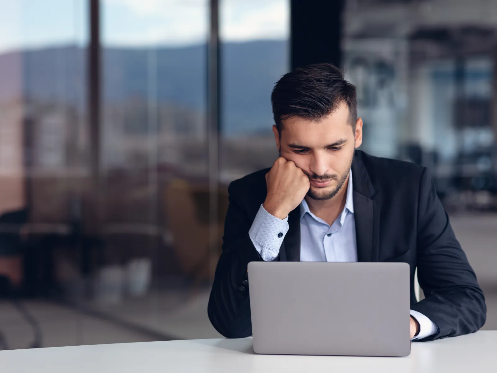 a man sitting at a table with a laptop