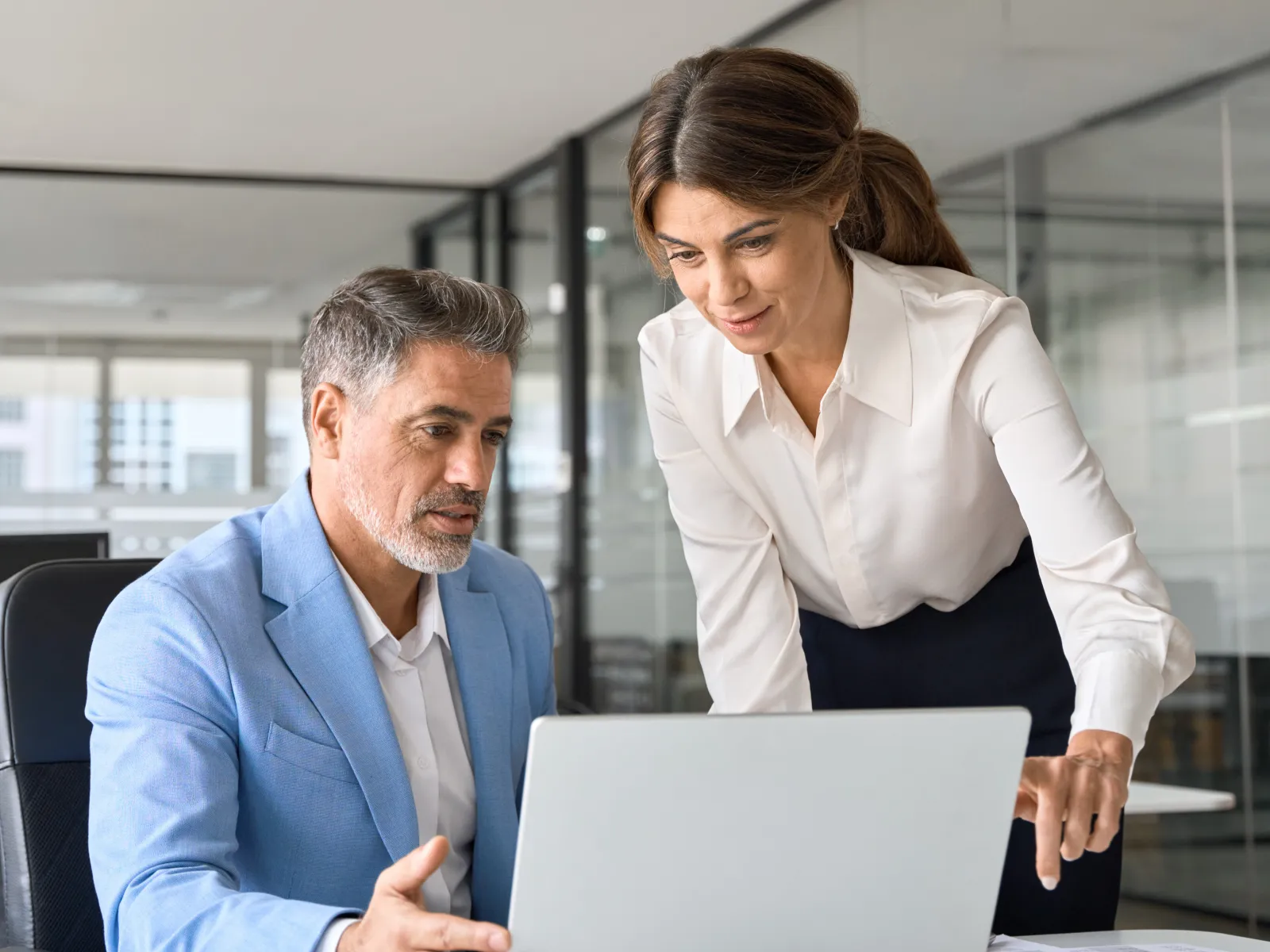 a man and a woman looking at a laptop