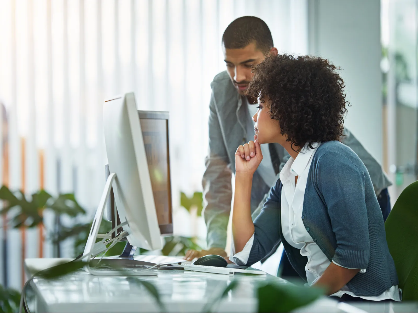 a man and a woman looking at a computer screen