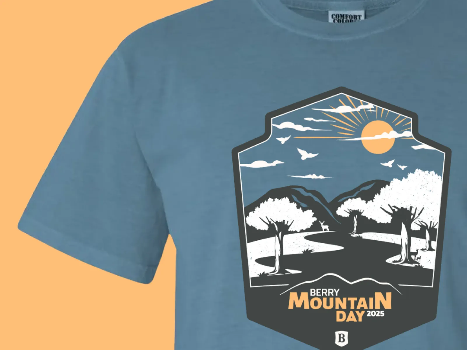 Blue t-shirt with a scenic Berry Mountain Day 2025 design featuring trees, mountains, sun, and birds.
