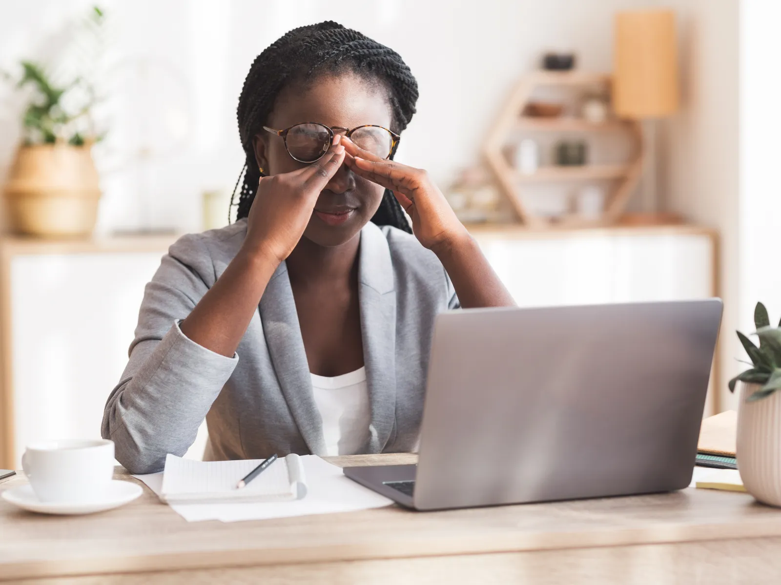 a woman with her hand on her face looking at a laptop