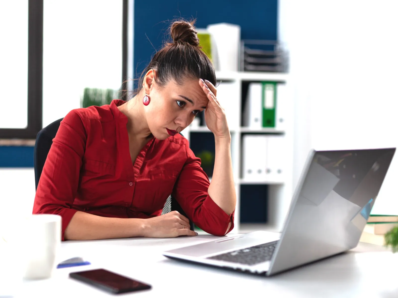 a woman sitting at a desk with a laptop