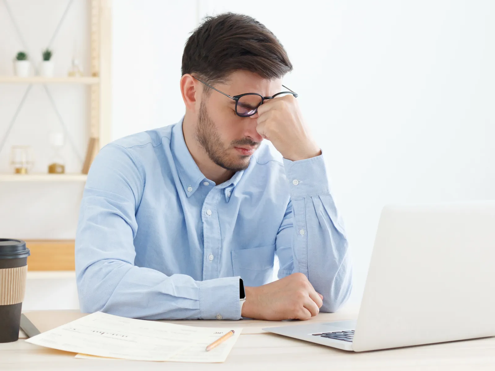 a man sitting at a desk with a laptop and papers