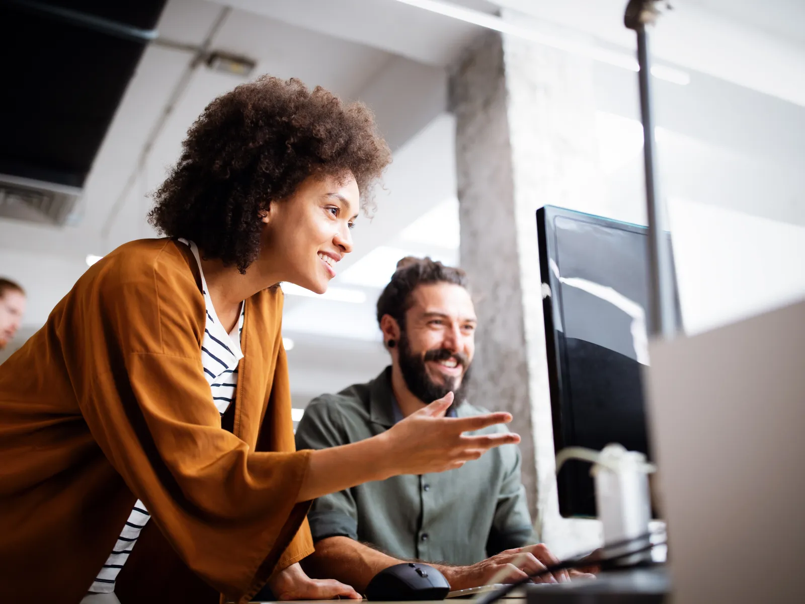 a woman and a man looking at a computer screen
