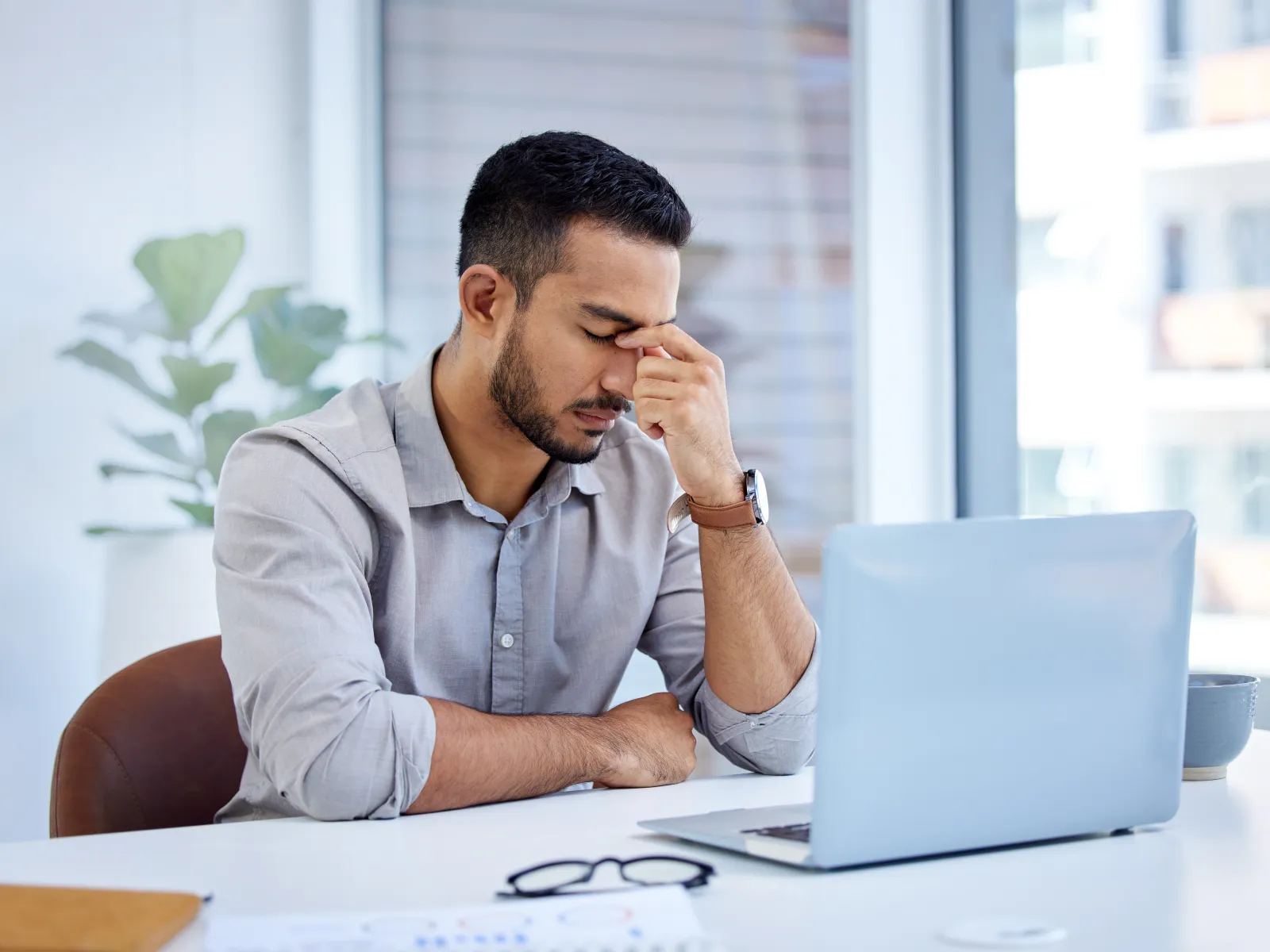a man sitting at a table with his hand on his face