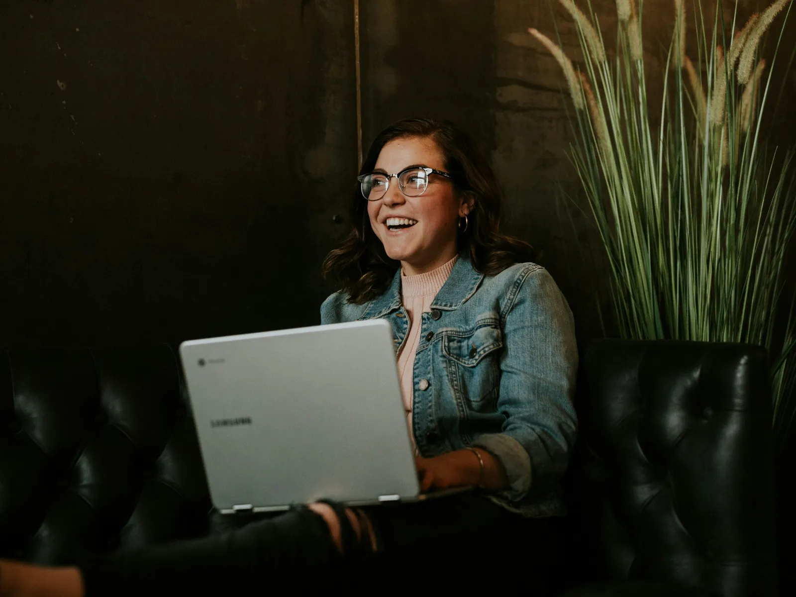 a person sitting on a couch with a laptop
