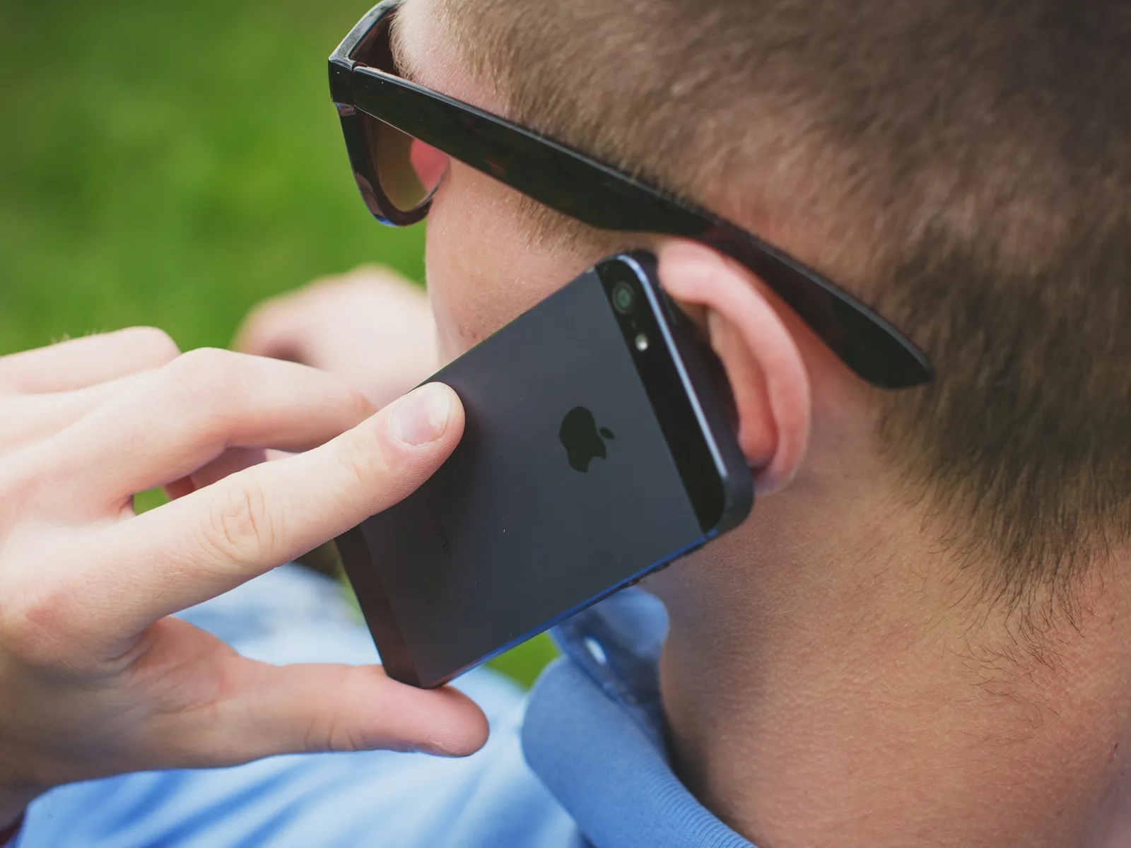 a man wearing sunglasses and holding a cell phone