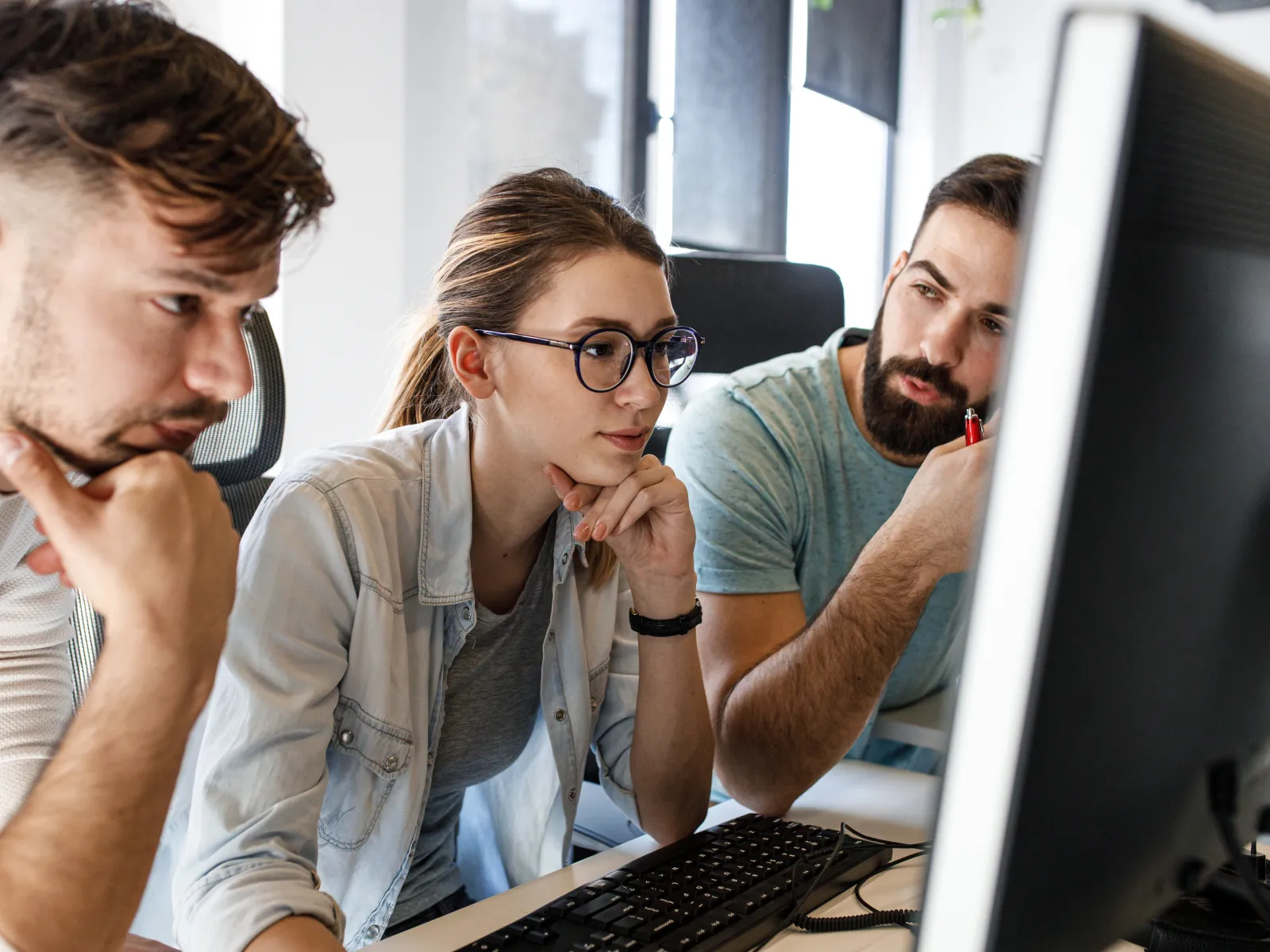 a group of people looking at a computer screen