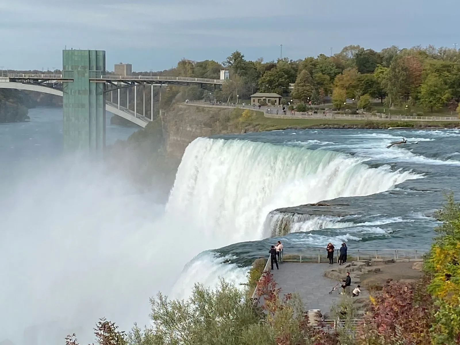 a waterfall with people walking on the side