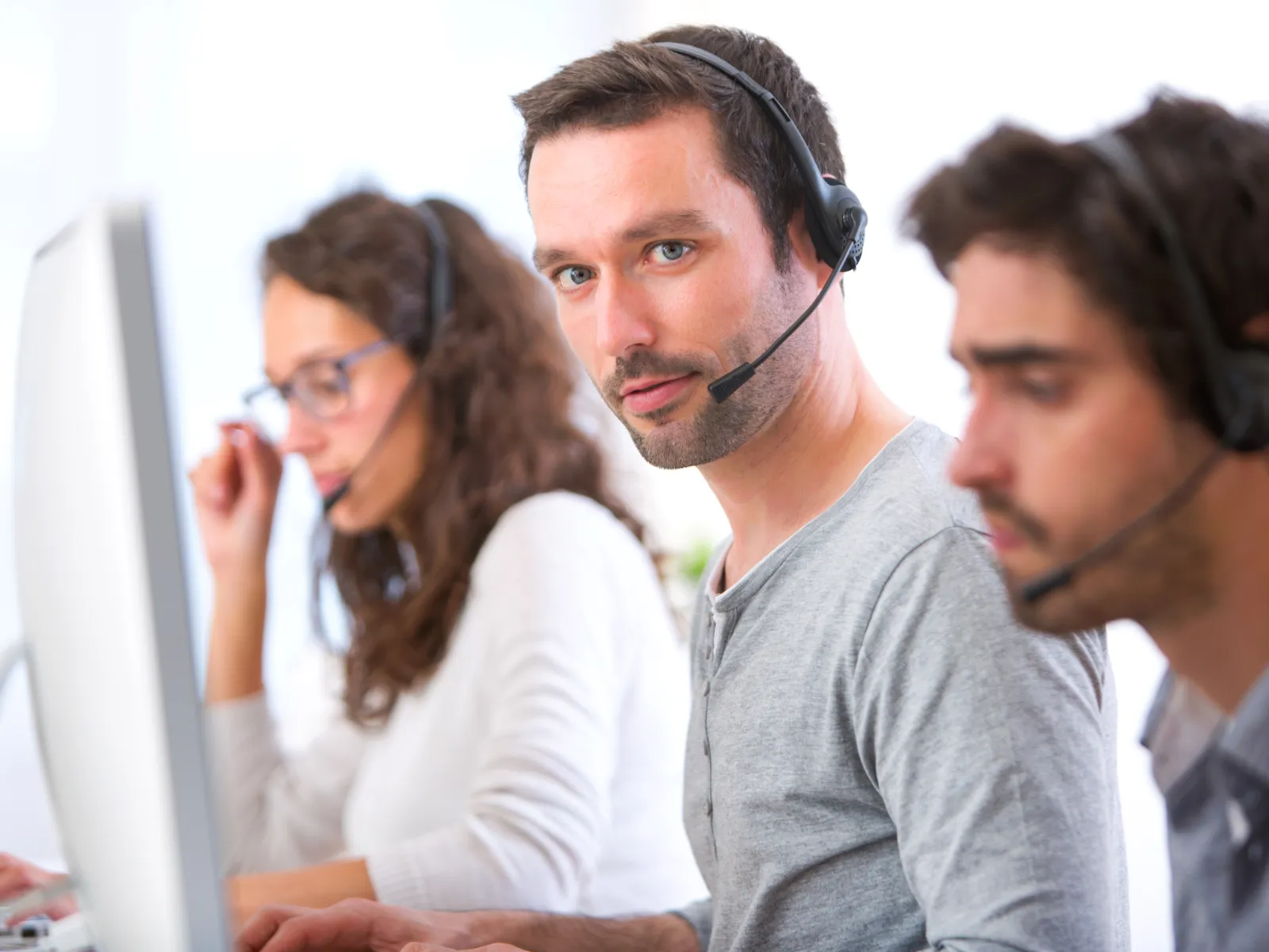 Customer service representatives wearing headsets working in a busy call center environment