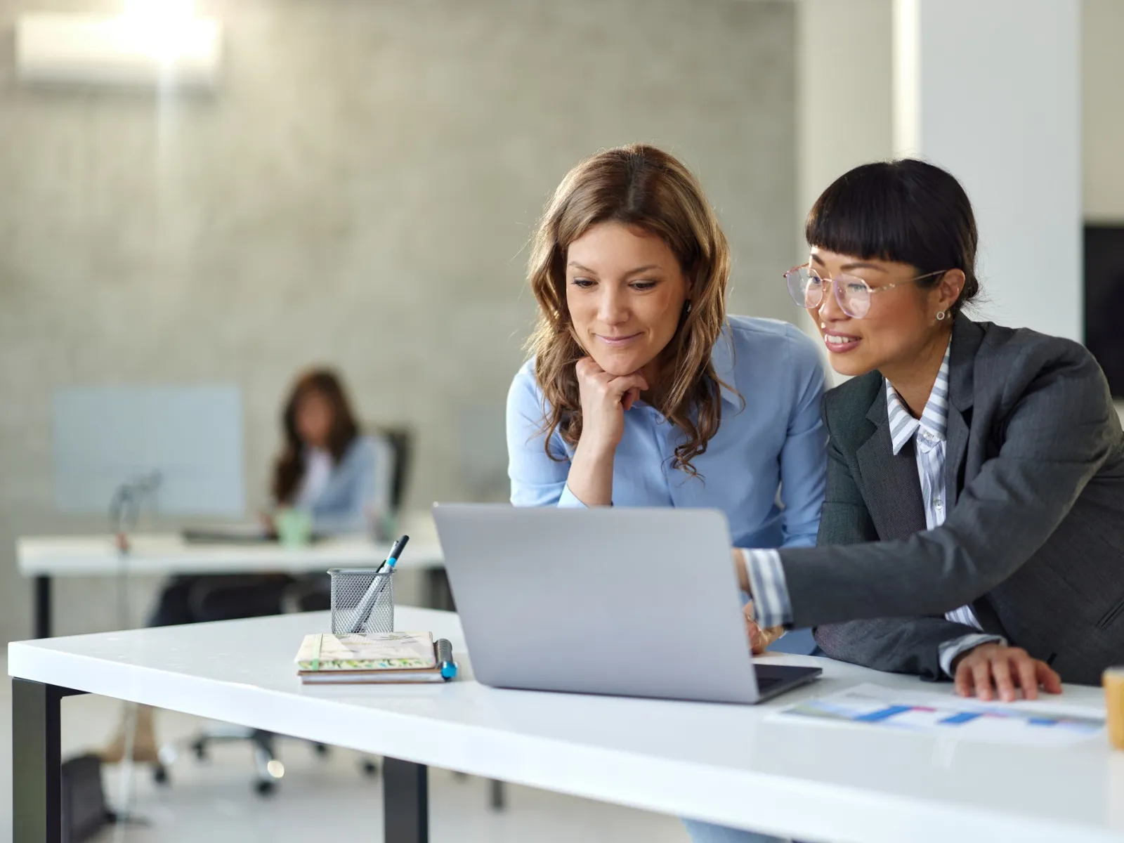 a woman and a man looking at a laptop