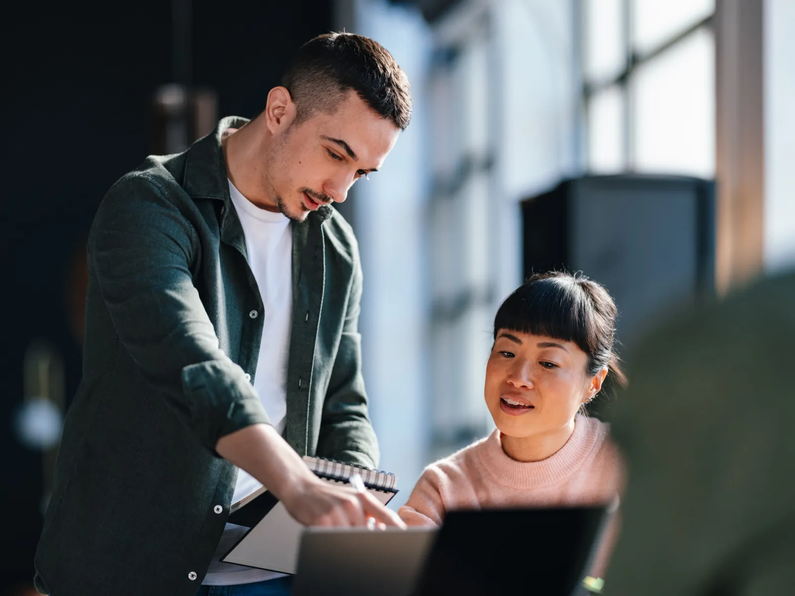 a man and a woman looking at a laptop