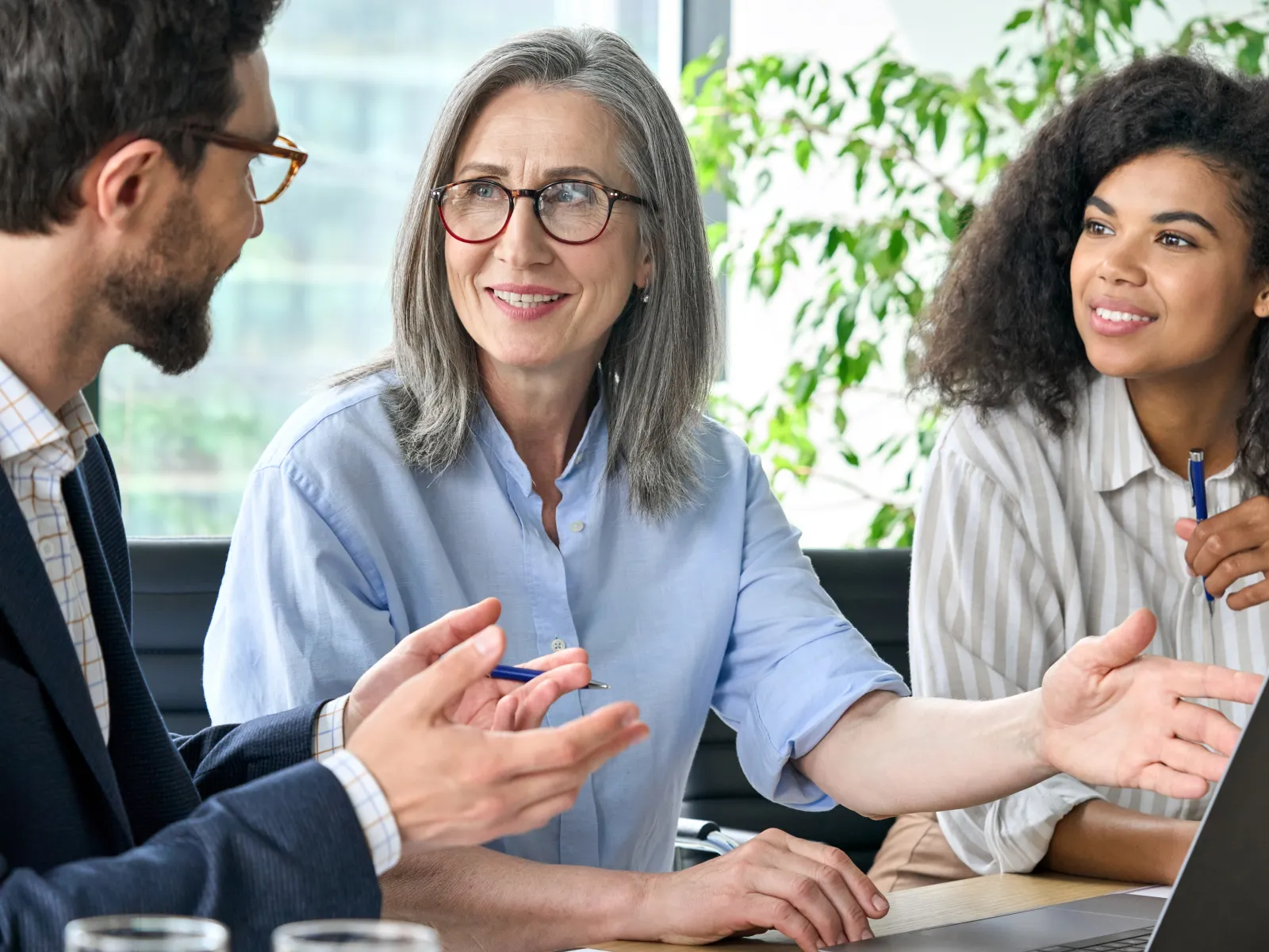 two women sitting at a table consulting with a man