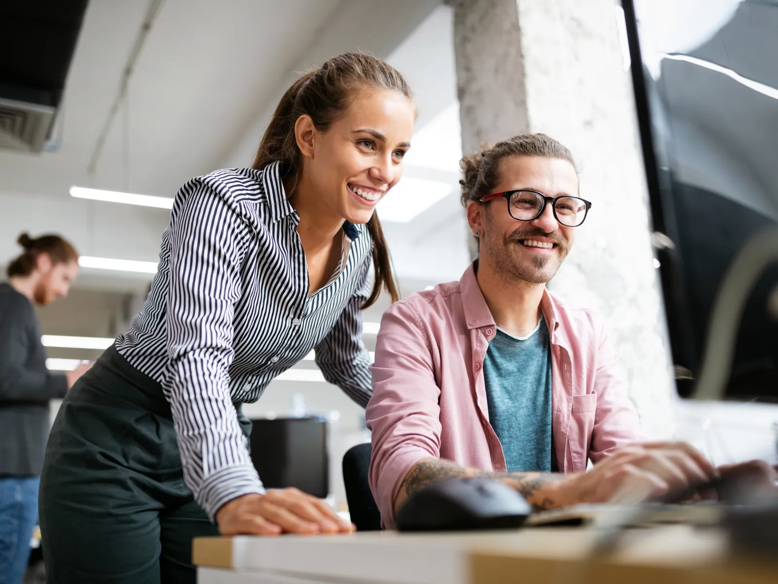 a man and a woman looking at a computer