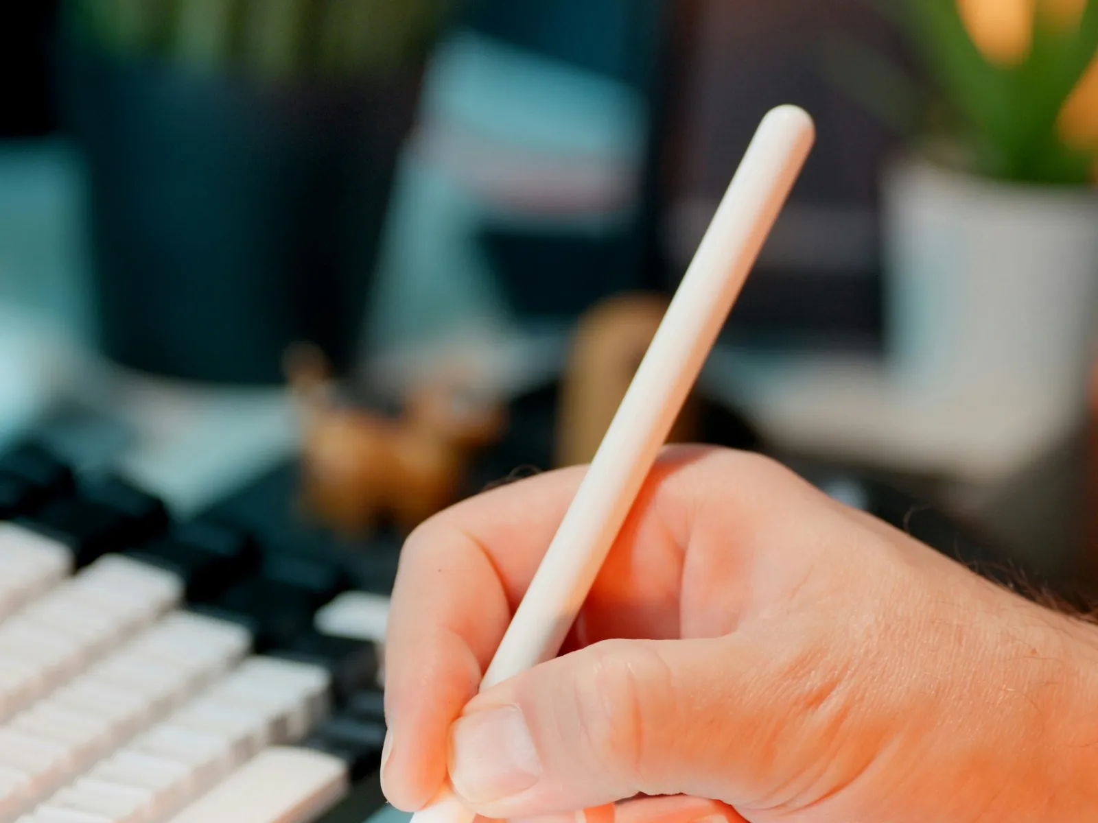 Close-up of hand using stylus on tablet to check off items on a digital to-do list at a desk.