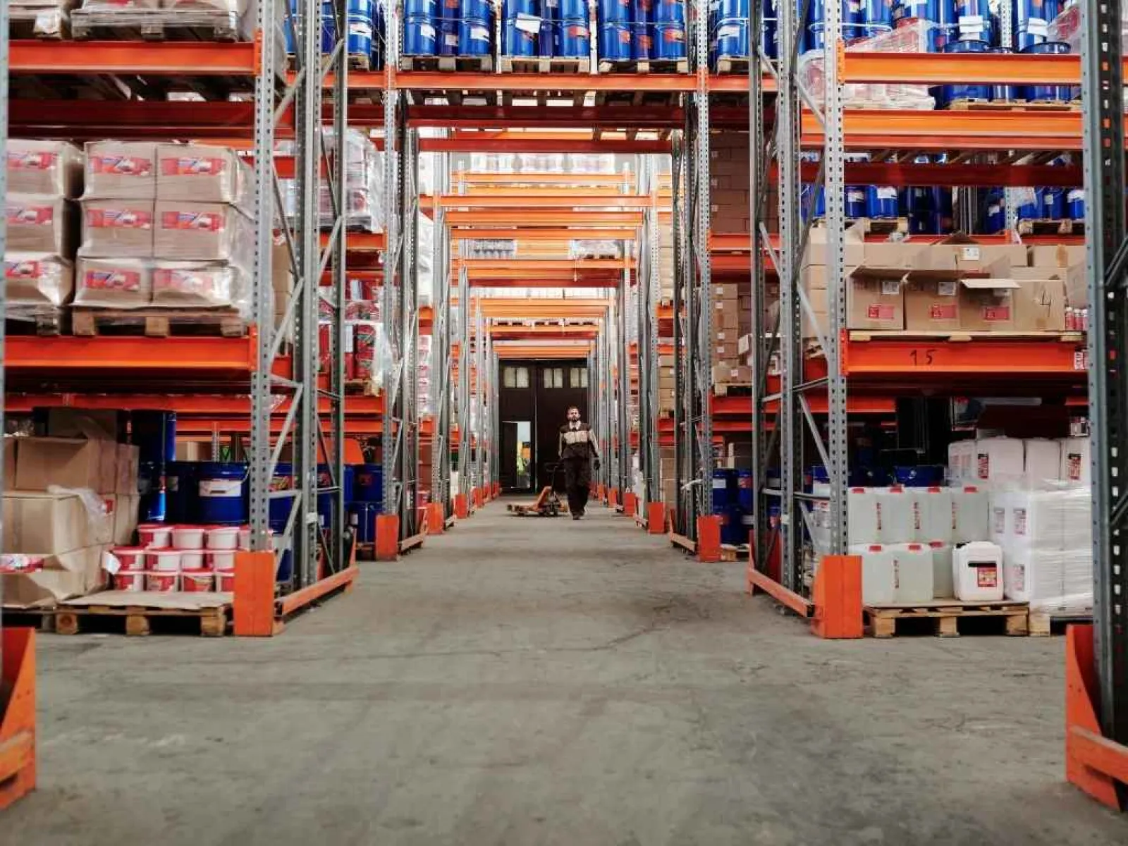 Recycling plant interior with blue conveyor belts, yellow railings, and scattered paper waste on concrete floor.