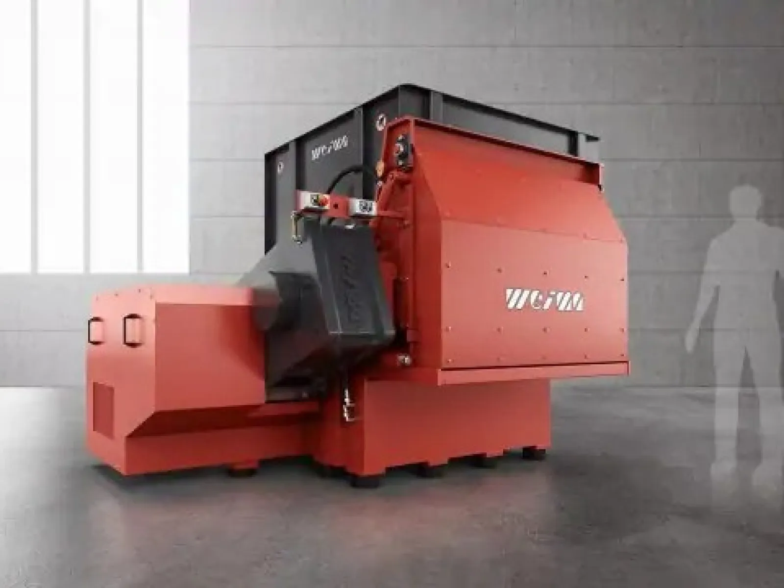 Industrial green baler machine compressing cardboard bales inside a warehouse.