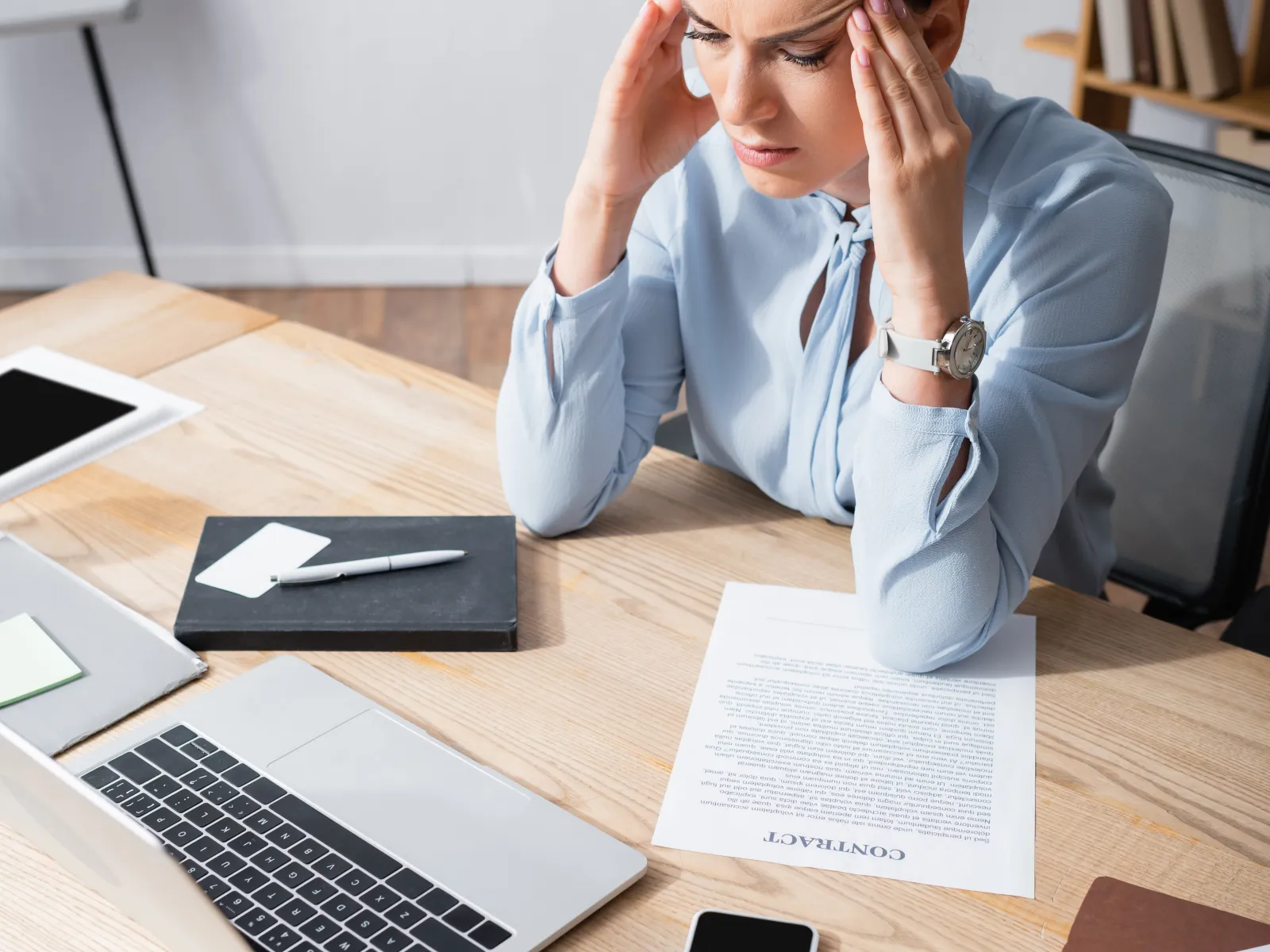 a person sitting at a desk with the hands on the face