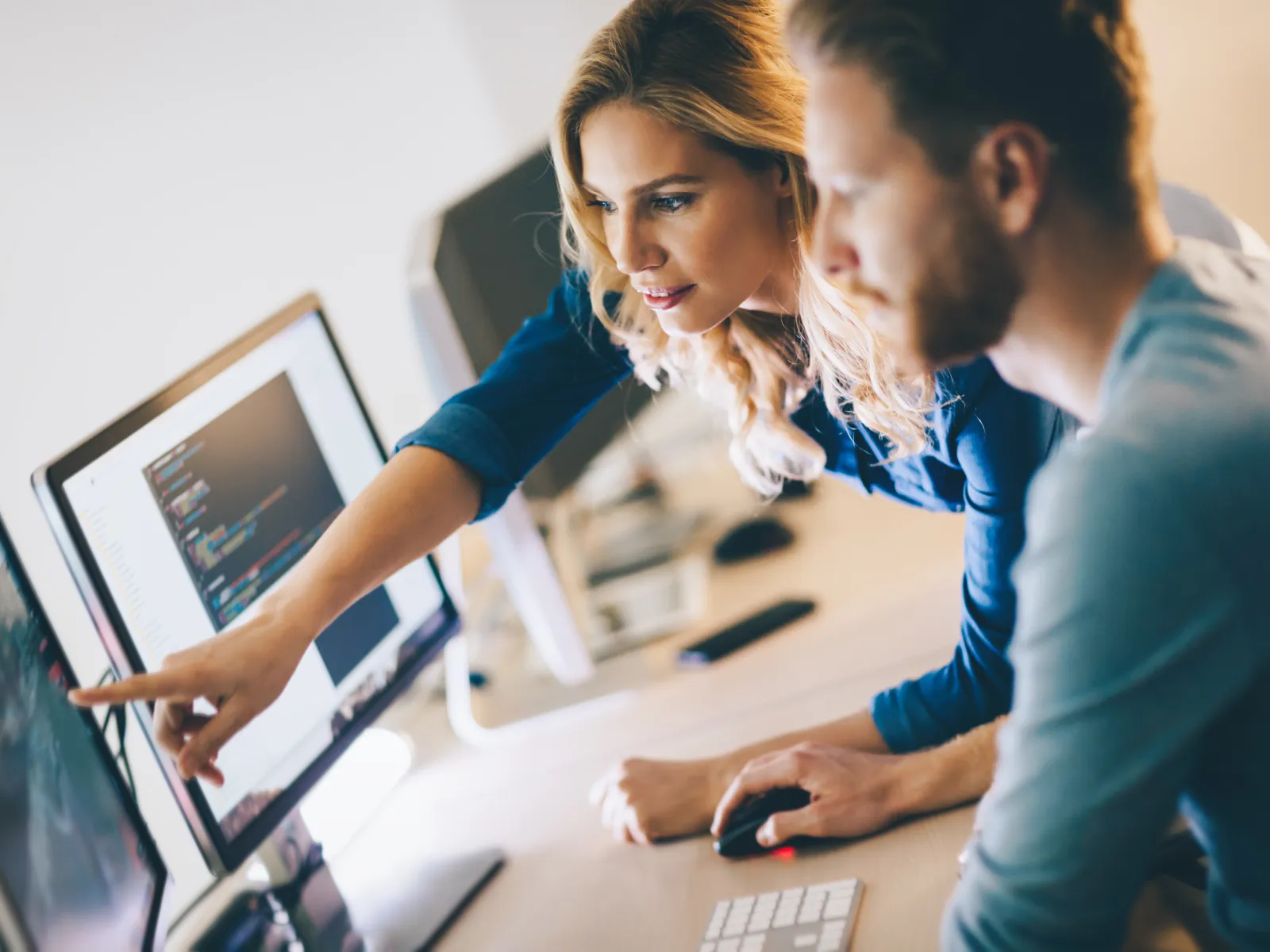 a man and a woman looking at a computer screen